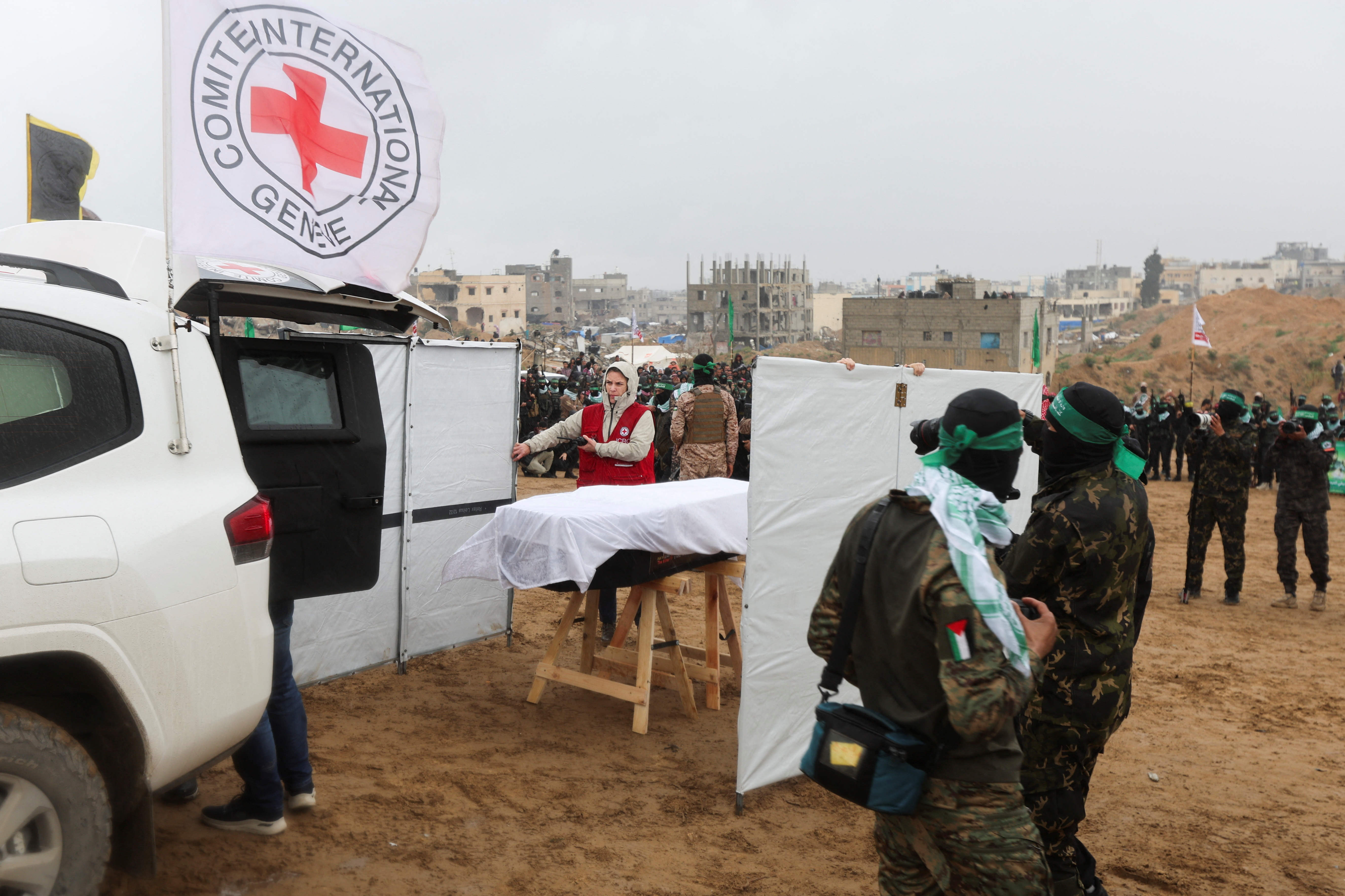 A member of the Red Cross stands near a coffin during the handover of the bodies.