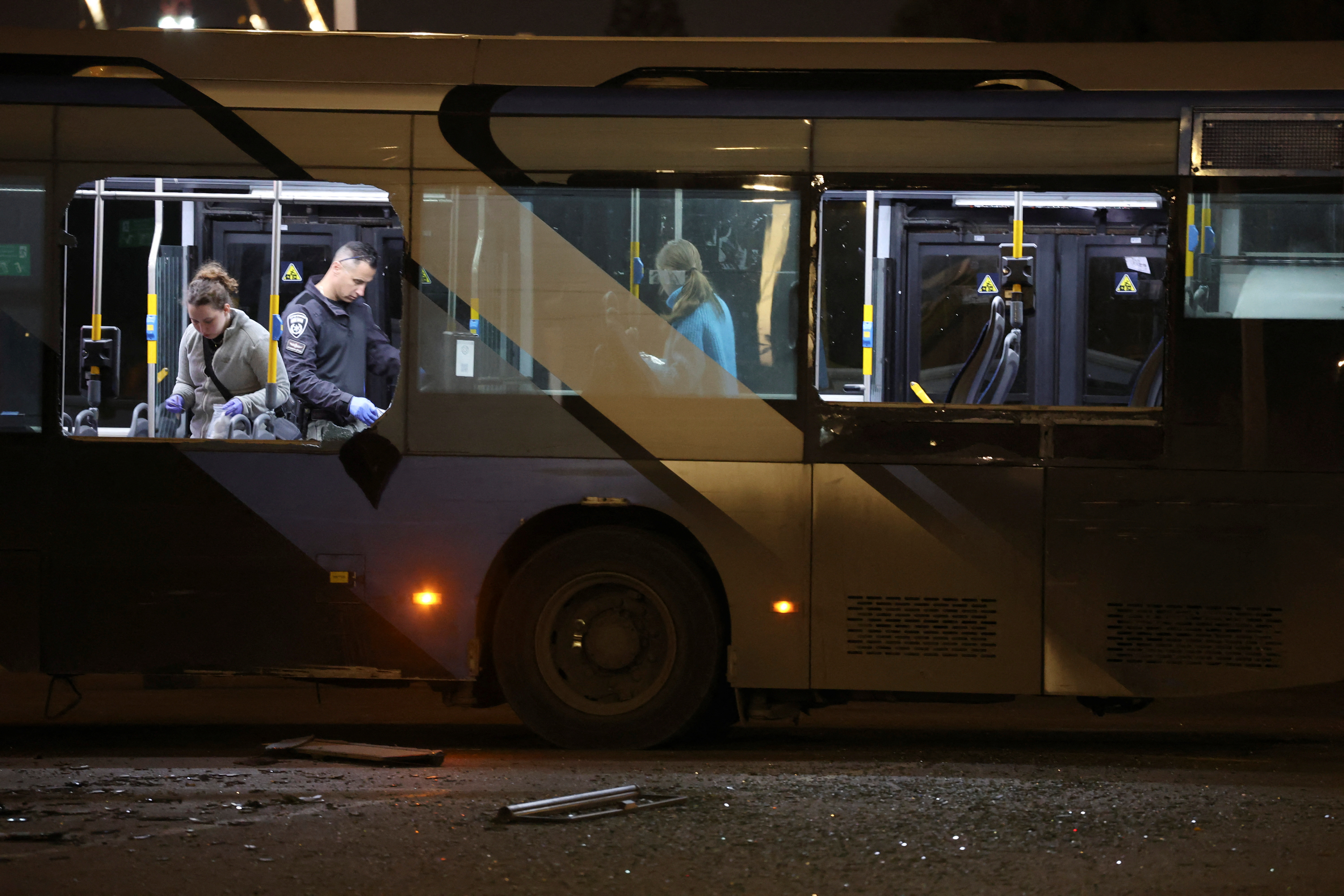 Authorities inspect a bus following its explosion.