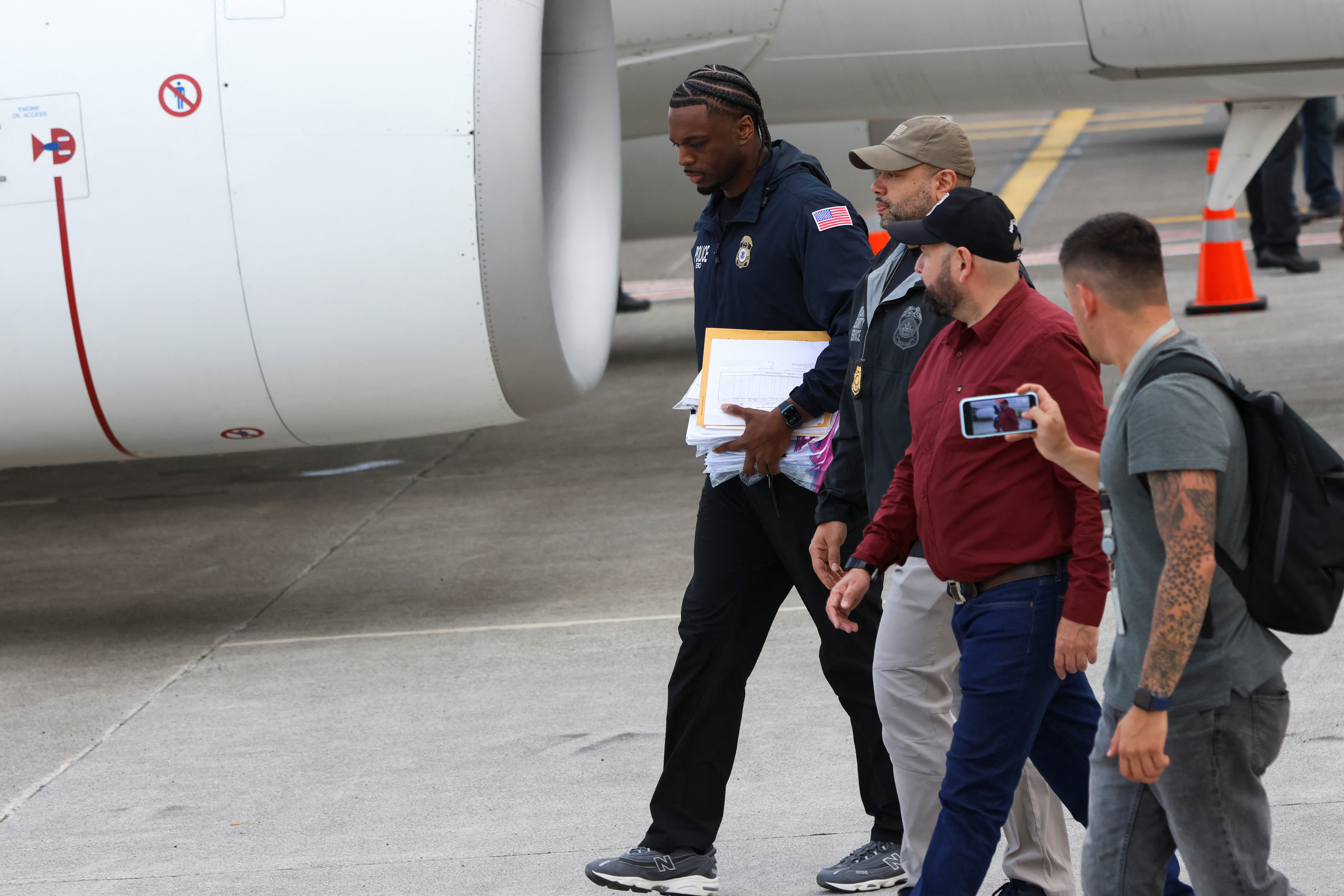 An officer walks as he carries the passports of migrants arriving in Costa Rica on a deportation flight from the US.