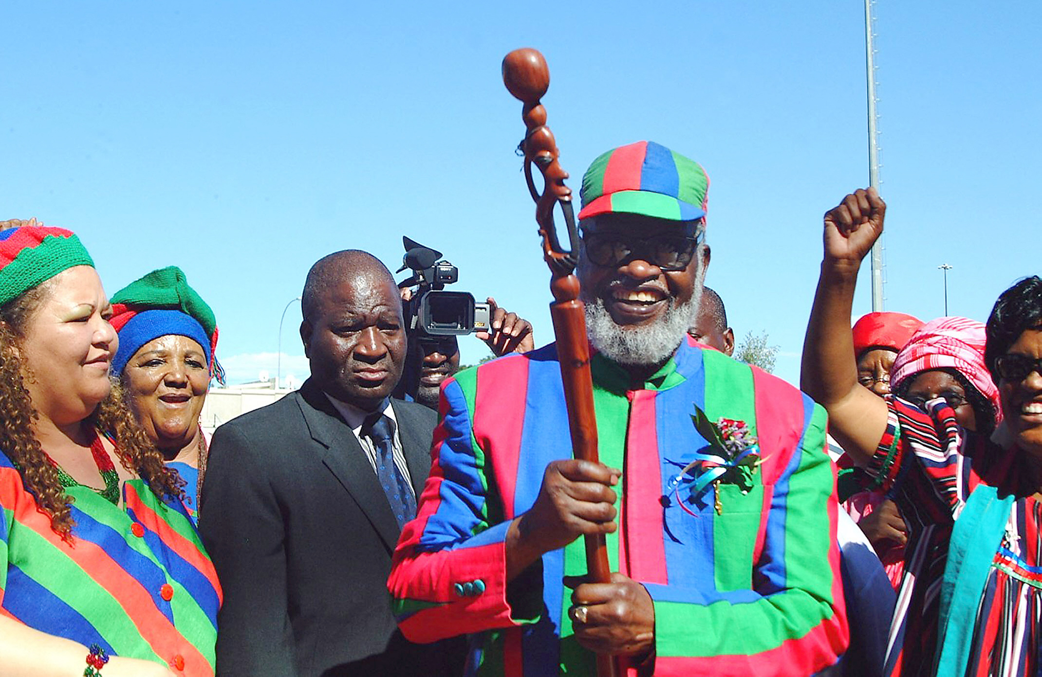 Namibian liberation hero and founding president Sam Nujoma (C) received a traditional walking stick, 01 December 2007 from women members of the ruling SWAPO party during a farewell rally in the capital of Windhoek. He also received a specially carved dining table set and a cow. Nujoma handed over leadership to head of state Hifikepunye Pohamba, who was Swapo vice-president and who elected unopposed during a Swapo congress. AFP PHOTO BRIGITTE WEIDLICH (Photo by BRIGITTE WEIDLICH / AFP)