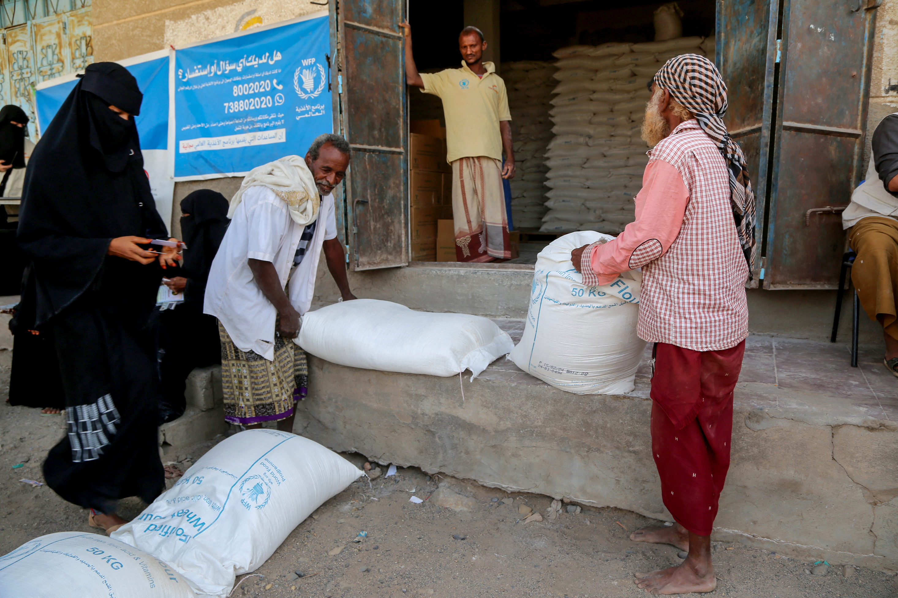 Displaced Yemenis receive humanitarian aid provided by the World Food Program in the Hays region, south of Hodeidah Governorate in western Yemen on February 24, 2024. (Photo by Khaled ZIAD / AFP)