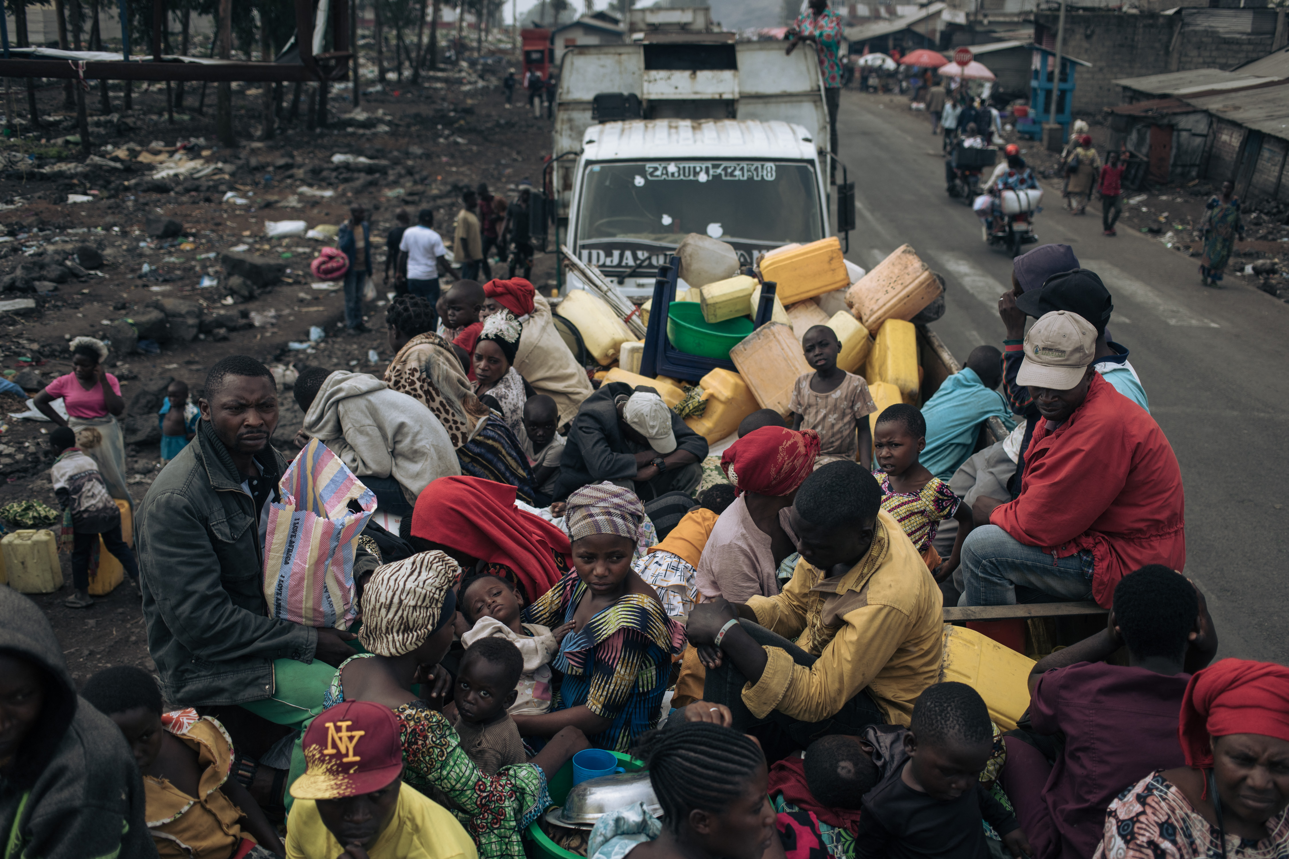 War-displaced people board trucks to leave the camps in Goma.
