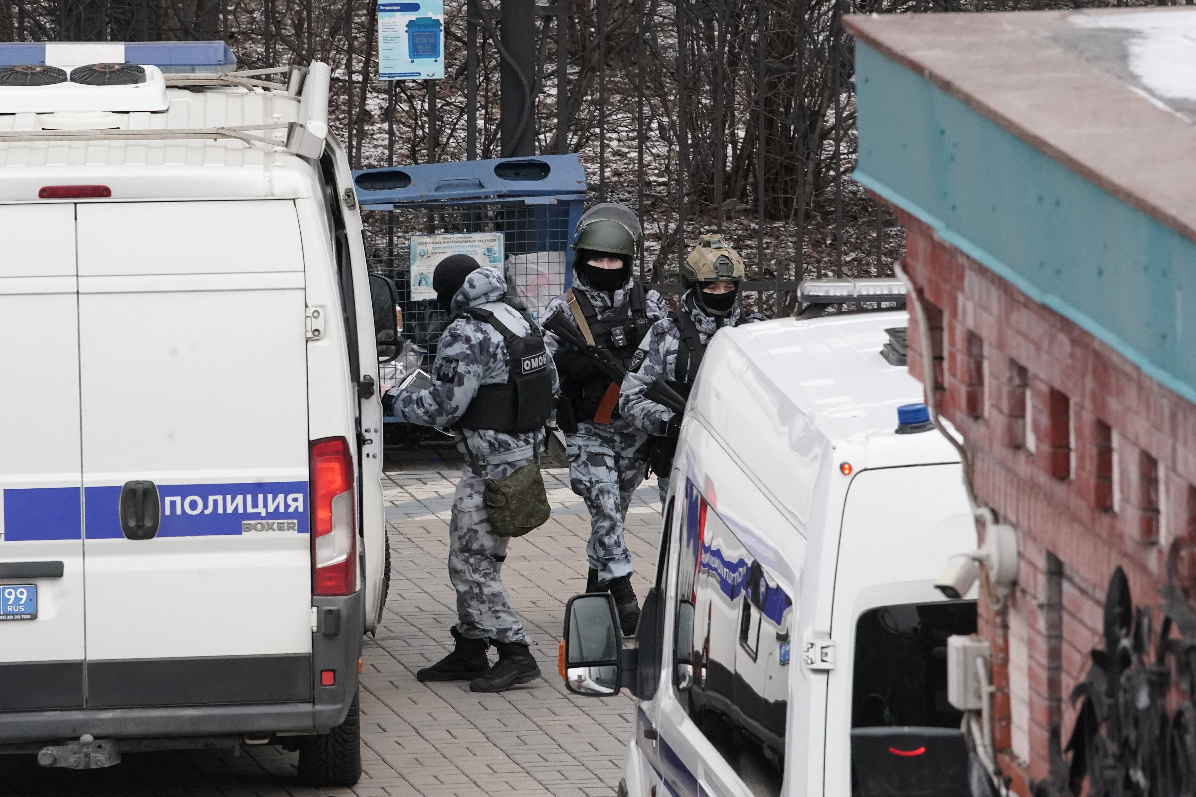 Russian law enforcement officers arrive in the courtyard of a residential building following a blast.