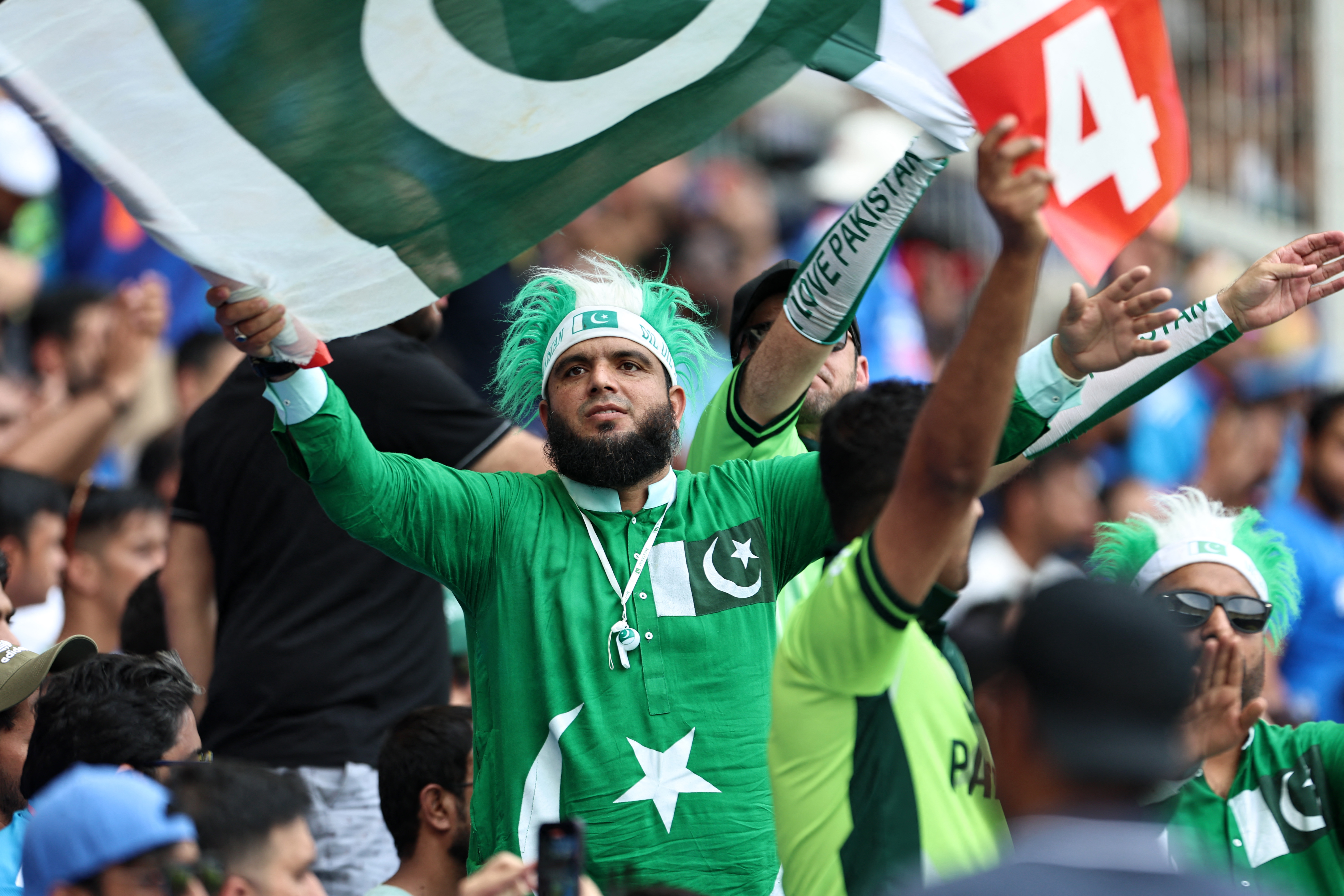 A Pakistan fan waves his country's national flag during the ICC Champions Trophy one-day international (ODI) cricket match between Pakistan and India at the Dubai International Stadium in Dubai on February 23, 2025. (Photo by FADEL SENNA / AFP)