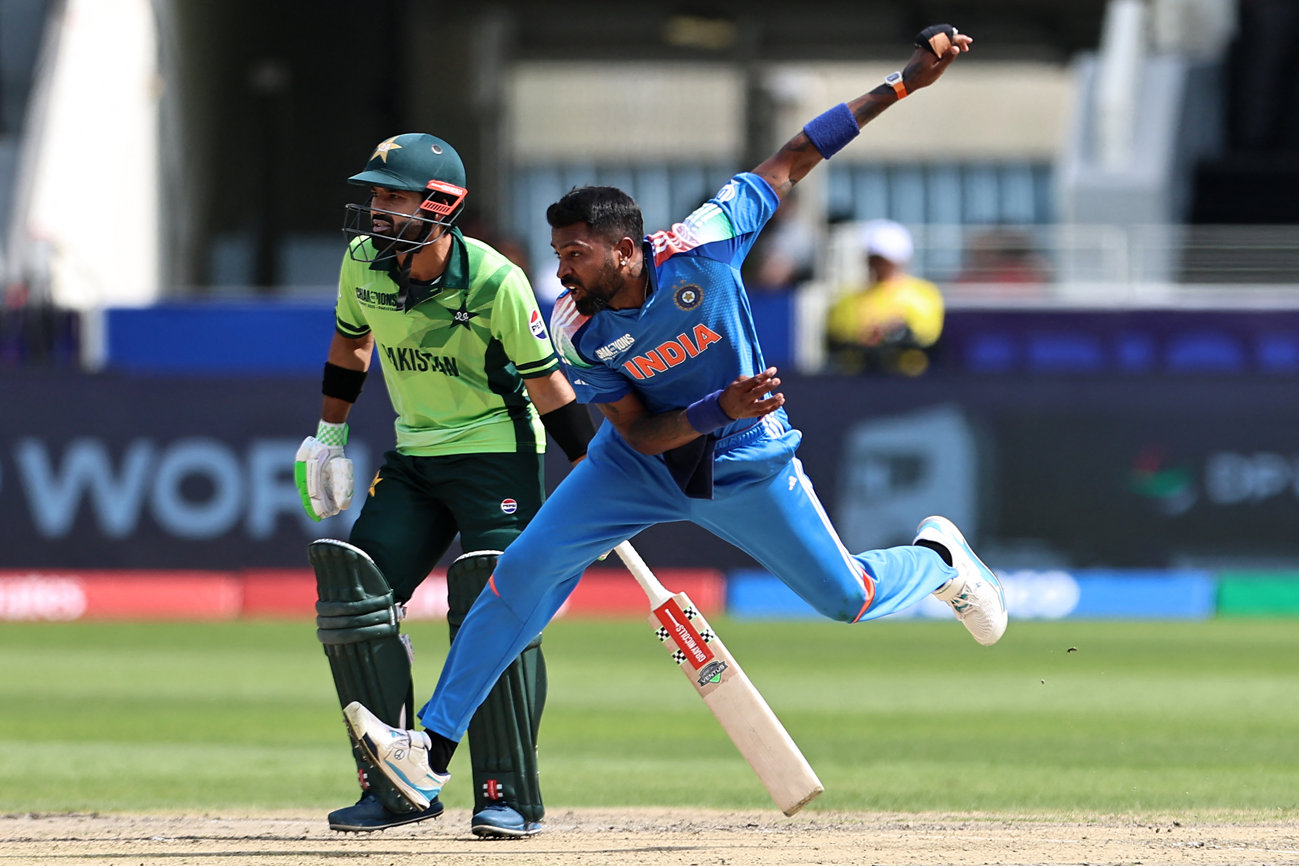India's Hardik Pandya (R) delivers a ball as Pakistan's captain Mohammad Rizwan looks on during the ICC Champions Trophy one-day international (ODI) cricket match between Pakistan and India at the Dubai International Stadium in Dubai on February 23, 2025. (Photo by FADEL SENNA / AFP)