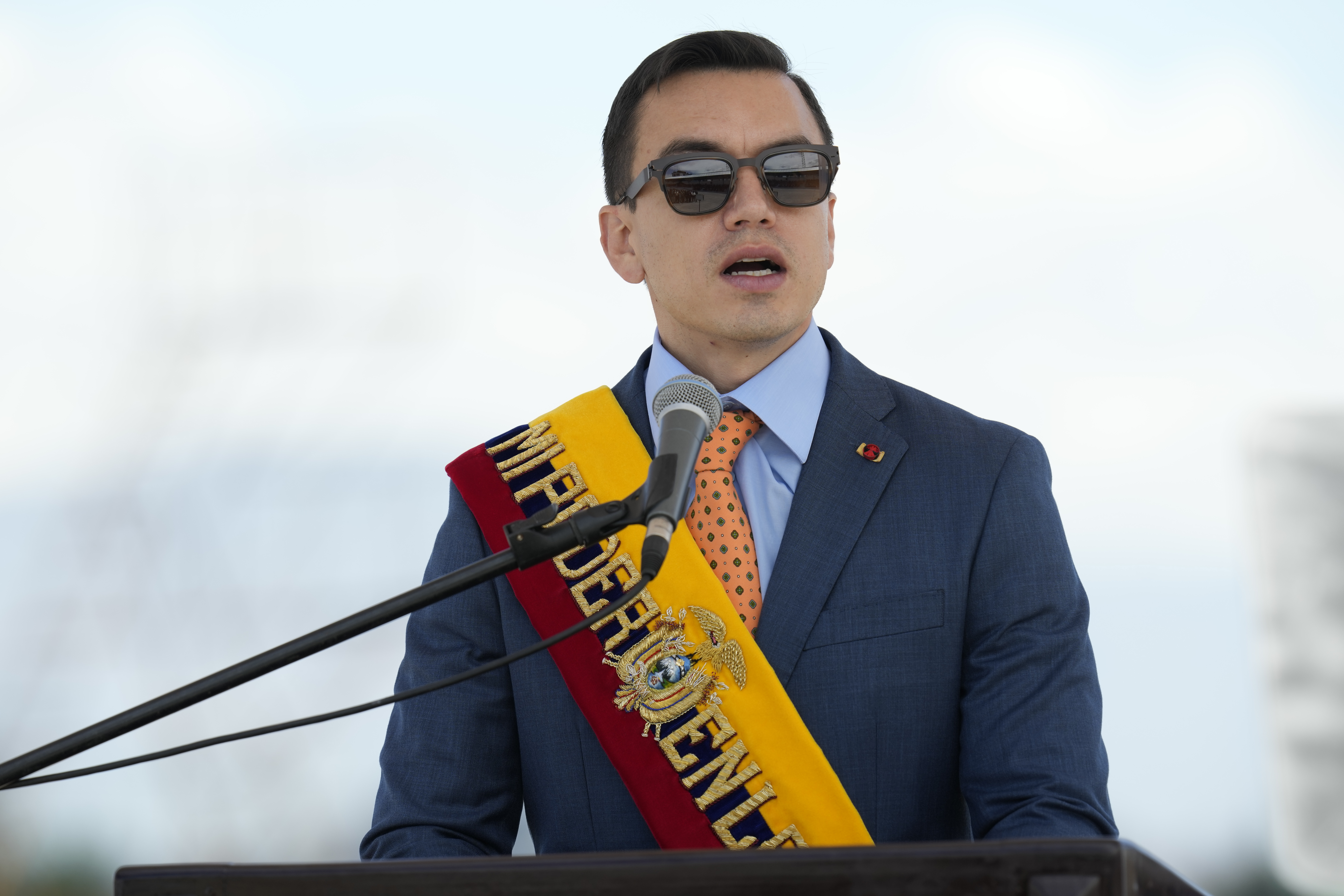 Daniel Noboa wearing a sash in the colors of the Ecuador flag and sunglasses