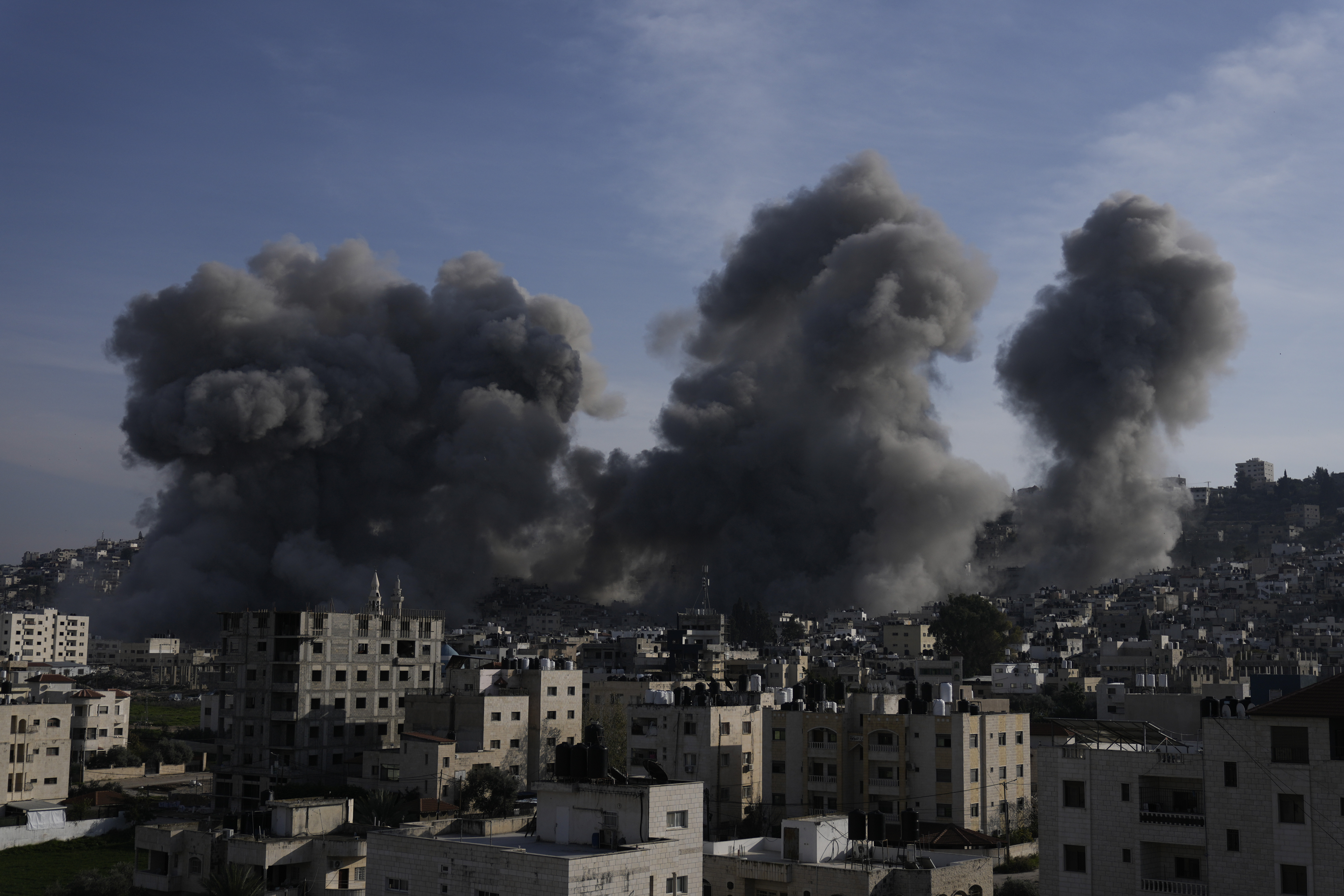 Smoke rises following Israeli army attacks, which destroyed buildings in the Jenin refugee camp in the occupied West Bank on February 2