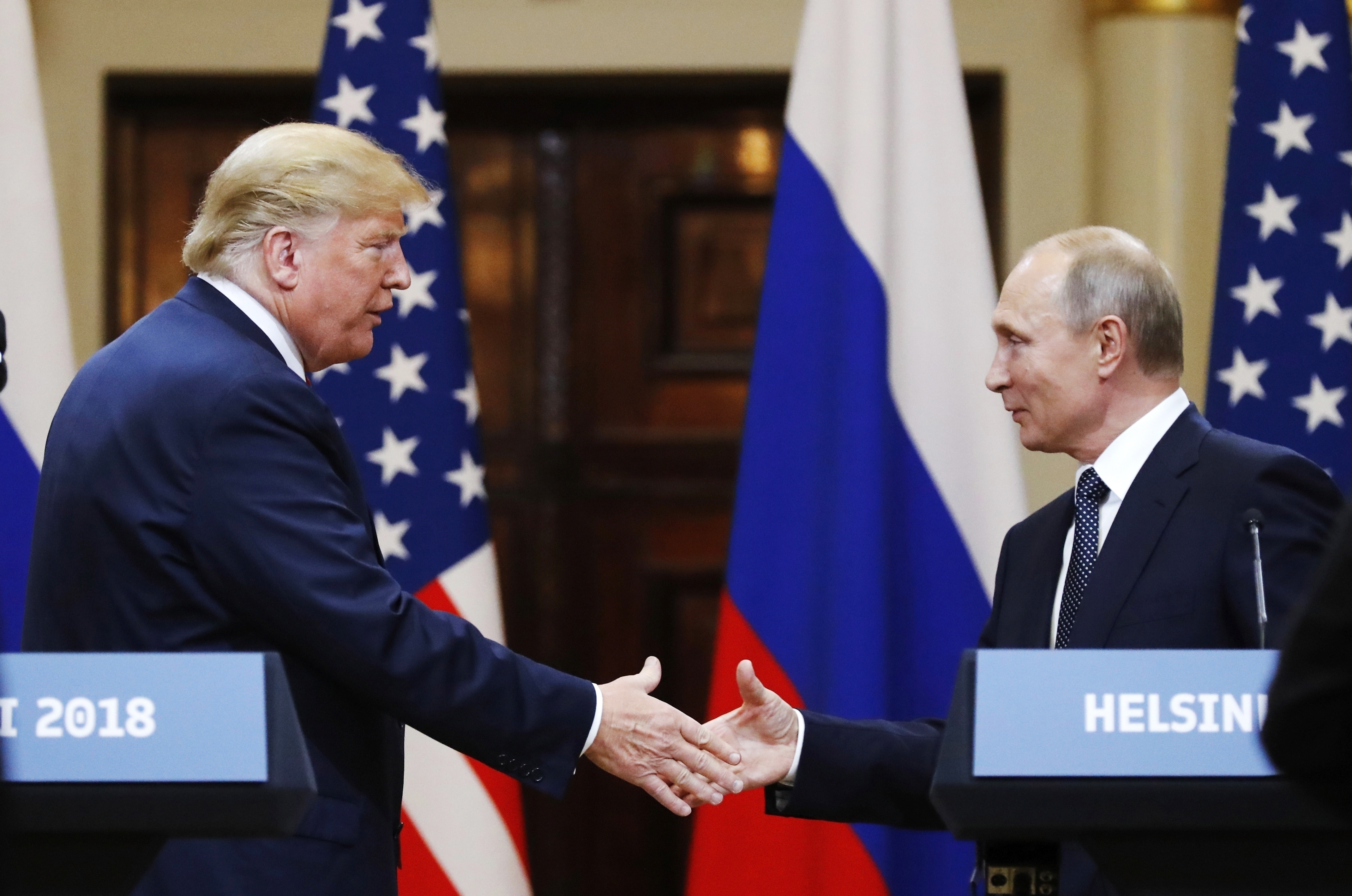 US President Donald Trump shakes hands with Russian President Vladimir Putin.