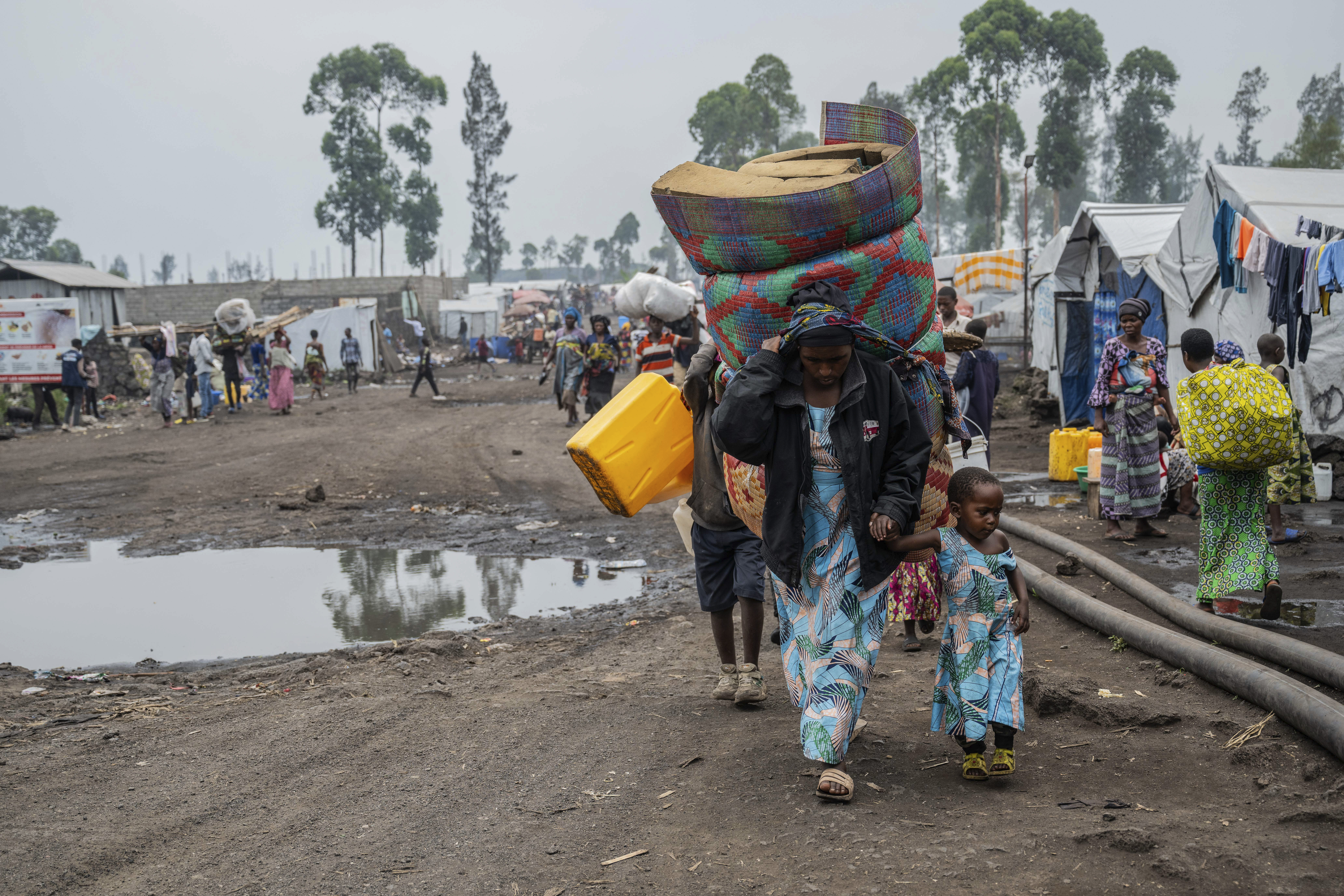 People who were displaced by the fighting between M23 rebels and government soldiers leave their camp following an instruction by M23 rebels in Goma, Democratic Republic of the Congo, Tuesday, Feb. 11, 2025. (AP Photo/Moses Sawasawa)