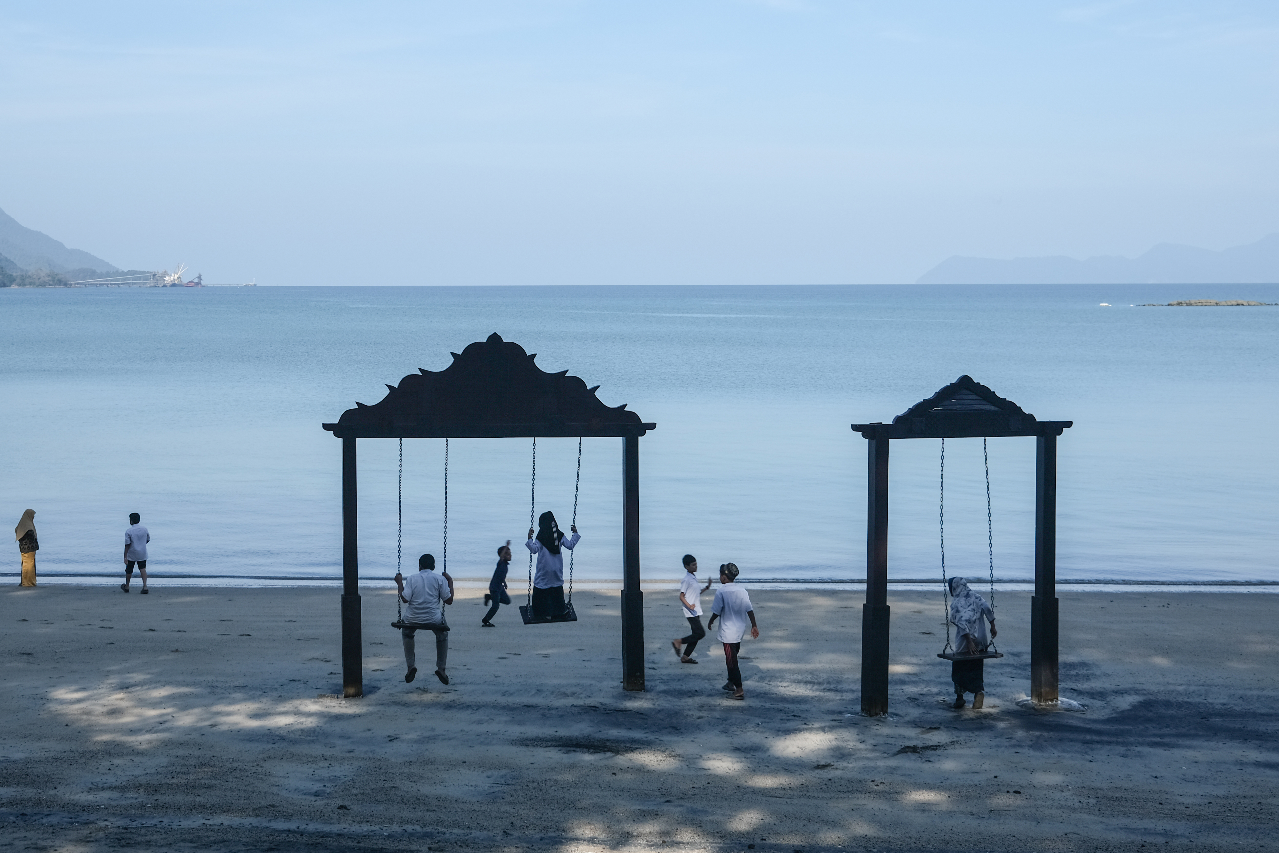 Rohingya children in Malaysia play on the beach.