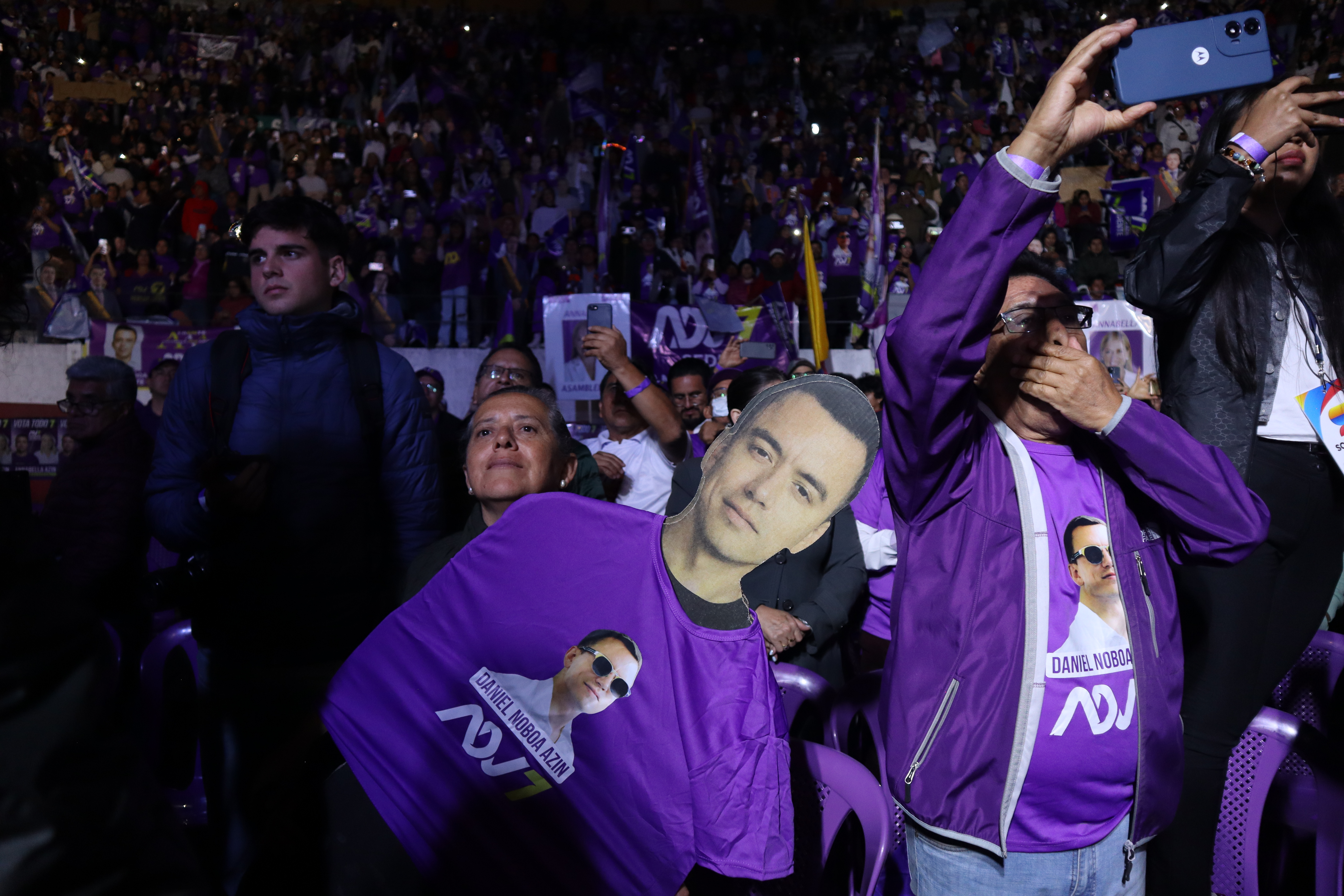 Supporters of Daniel Noboa cheer and clutch a cardboard cut-out of the leader