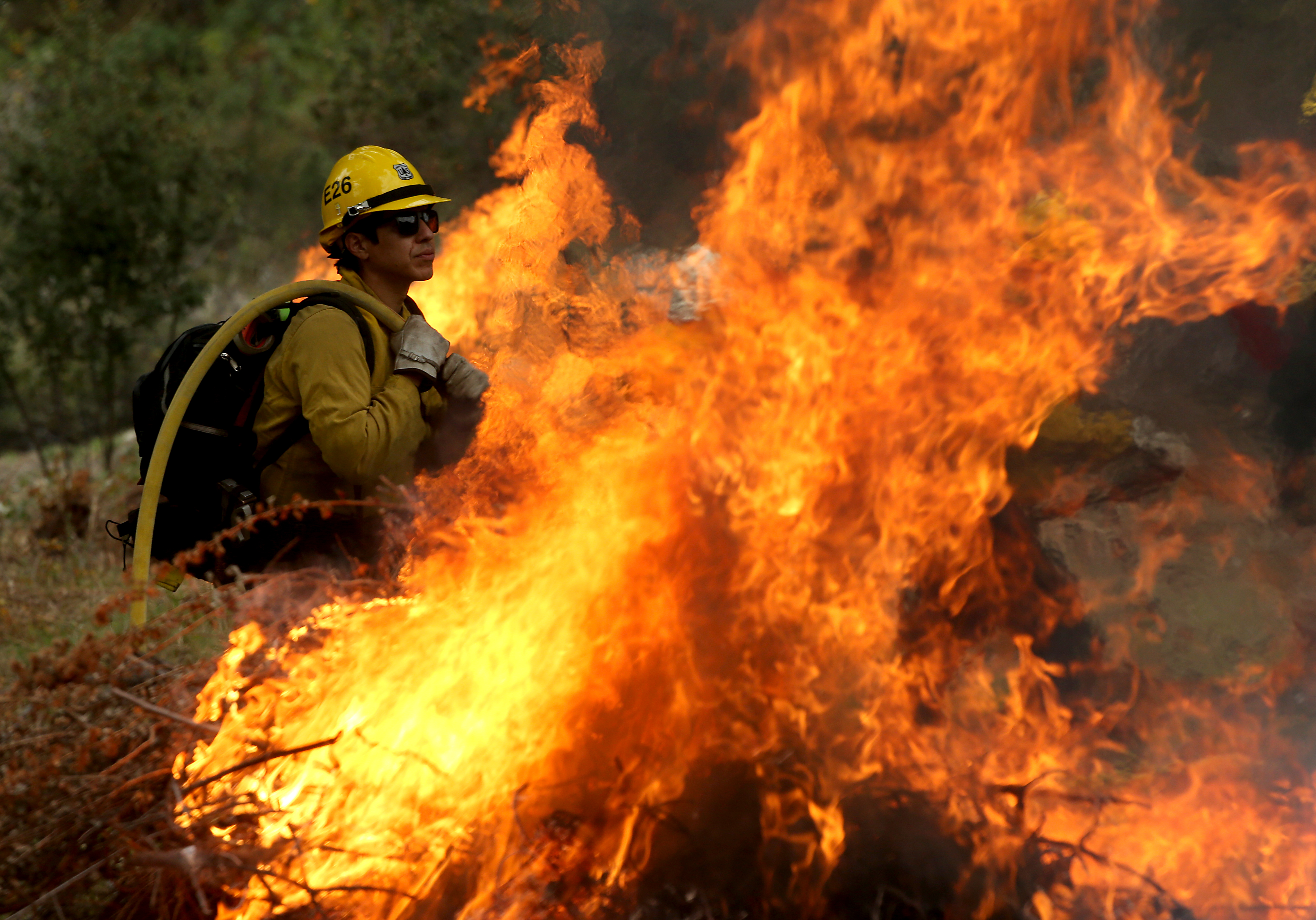 US Forest Service firefighters in the Angeles National Forest carry out a controlled burning of piles of forest debris below Mount Baldy on November 29, 2023, as part of the service's forest management practices [Luis Sinco/Los Angeles Times via Getty Images]