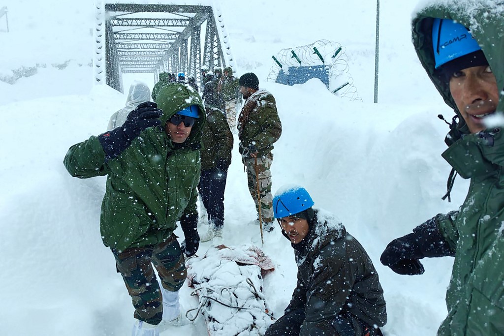 Rescuers carry injured workers after an avalanche.