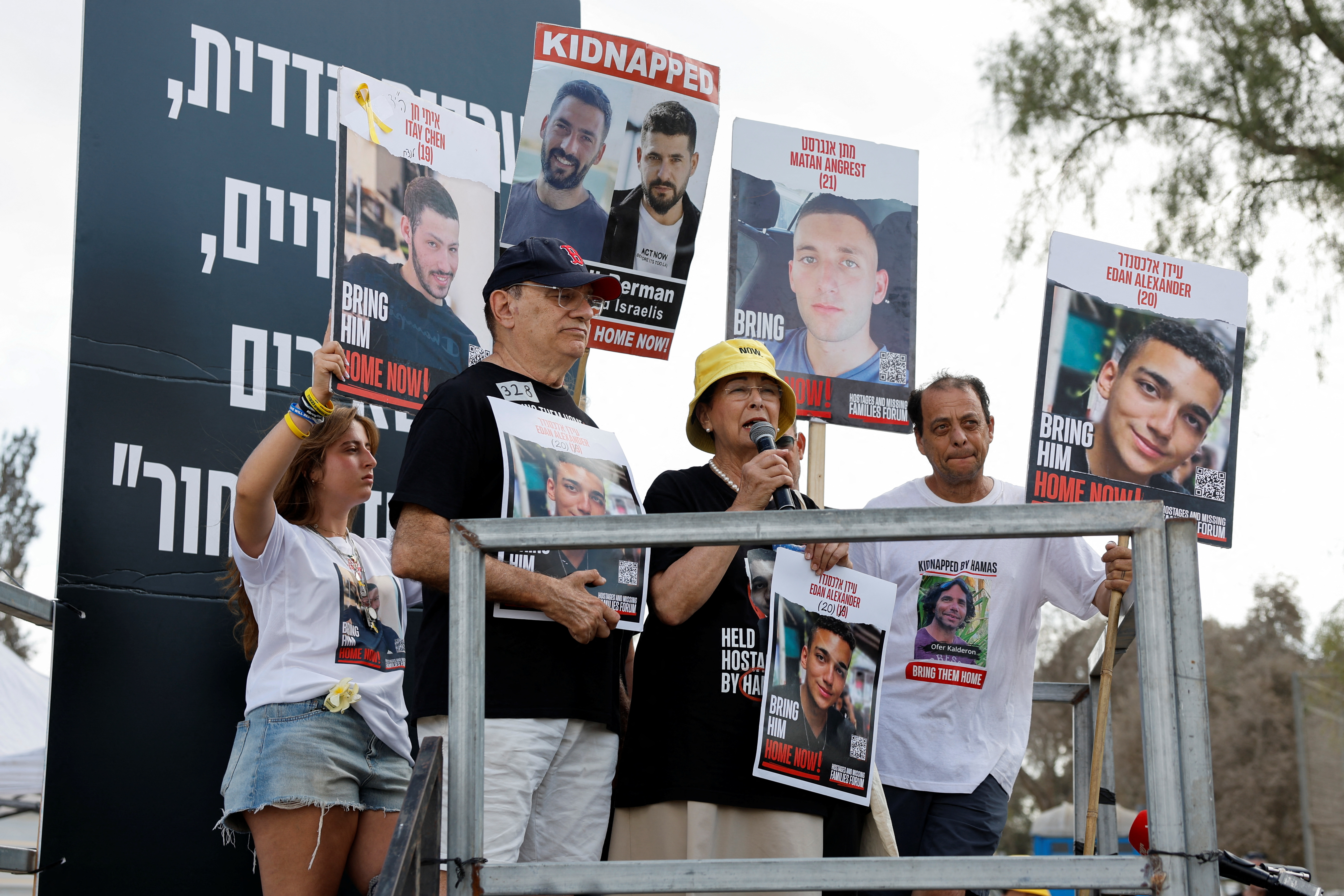 Yael Alexander, mother of hostage Edan Alexander, speaks through a microphone at a rally.