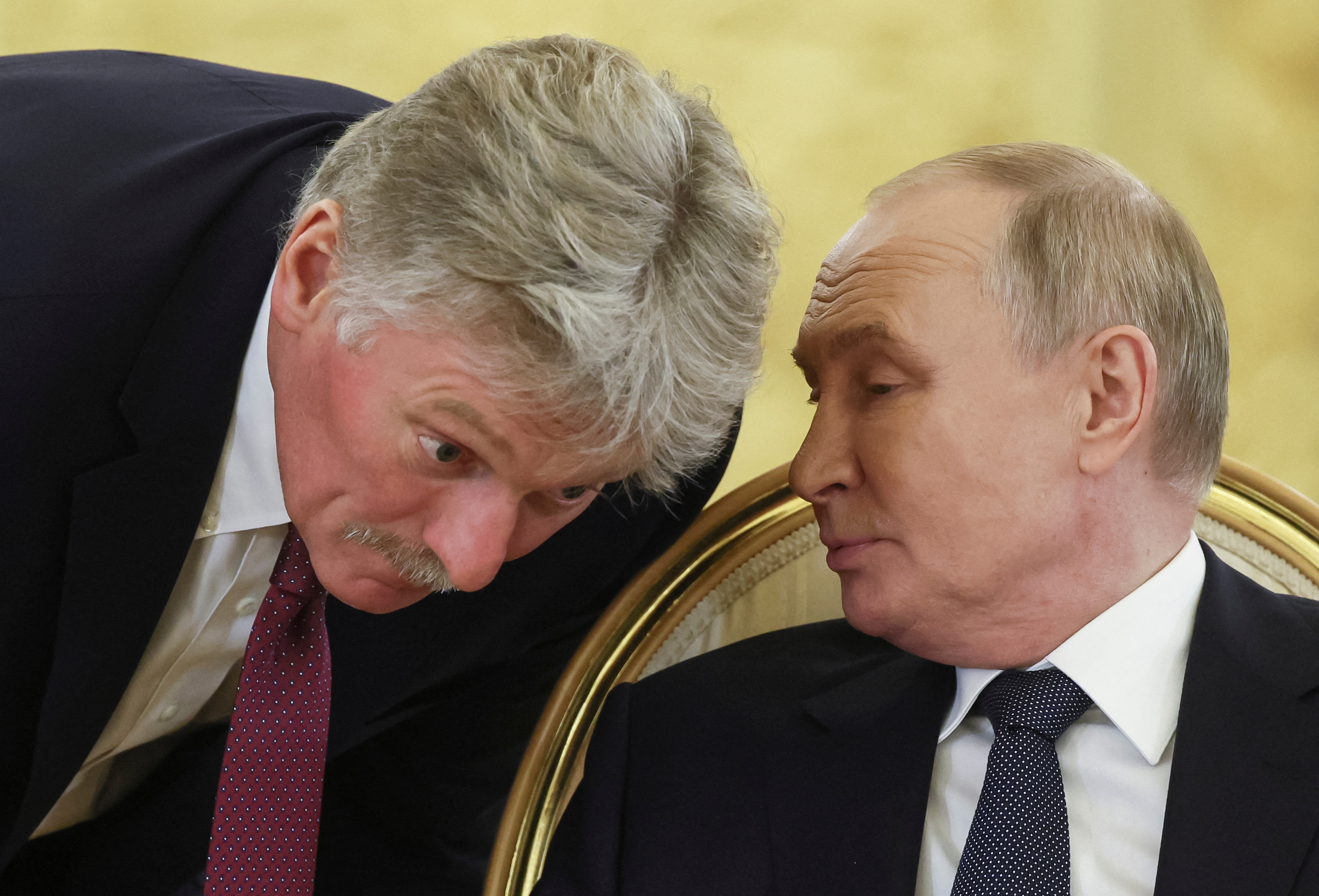 Russian President Vladimir Putin speaks with Kremlin spokesman Dmitry Peskov