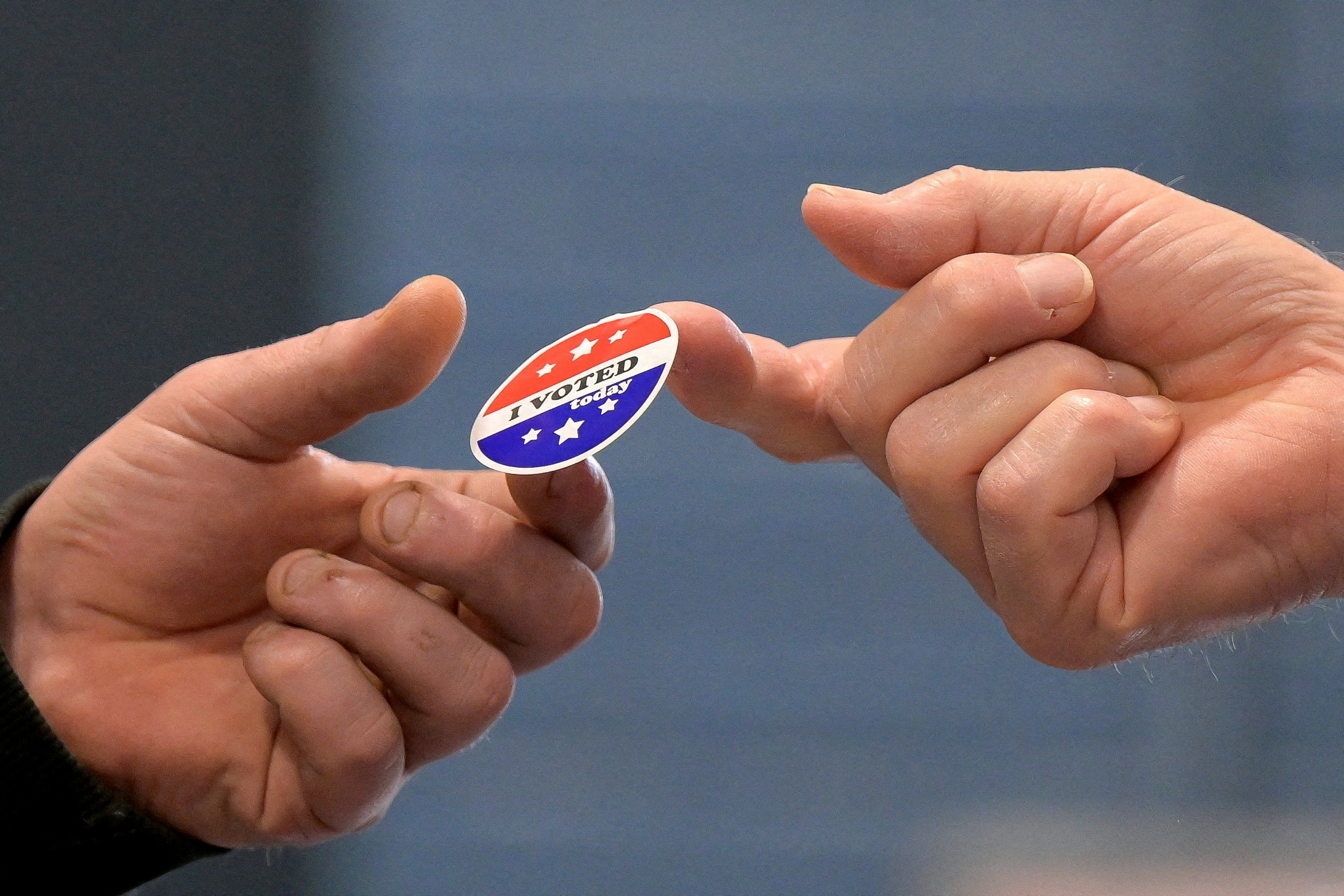 A voter receives a sticker after casting his ballot at New Begin Hall during the 2024 U.S. presidential election on Election Day