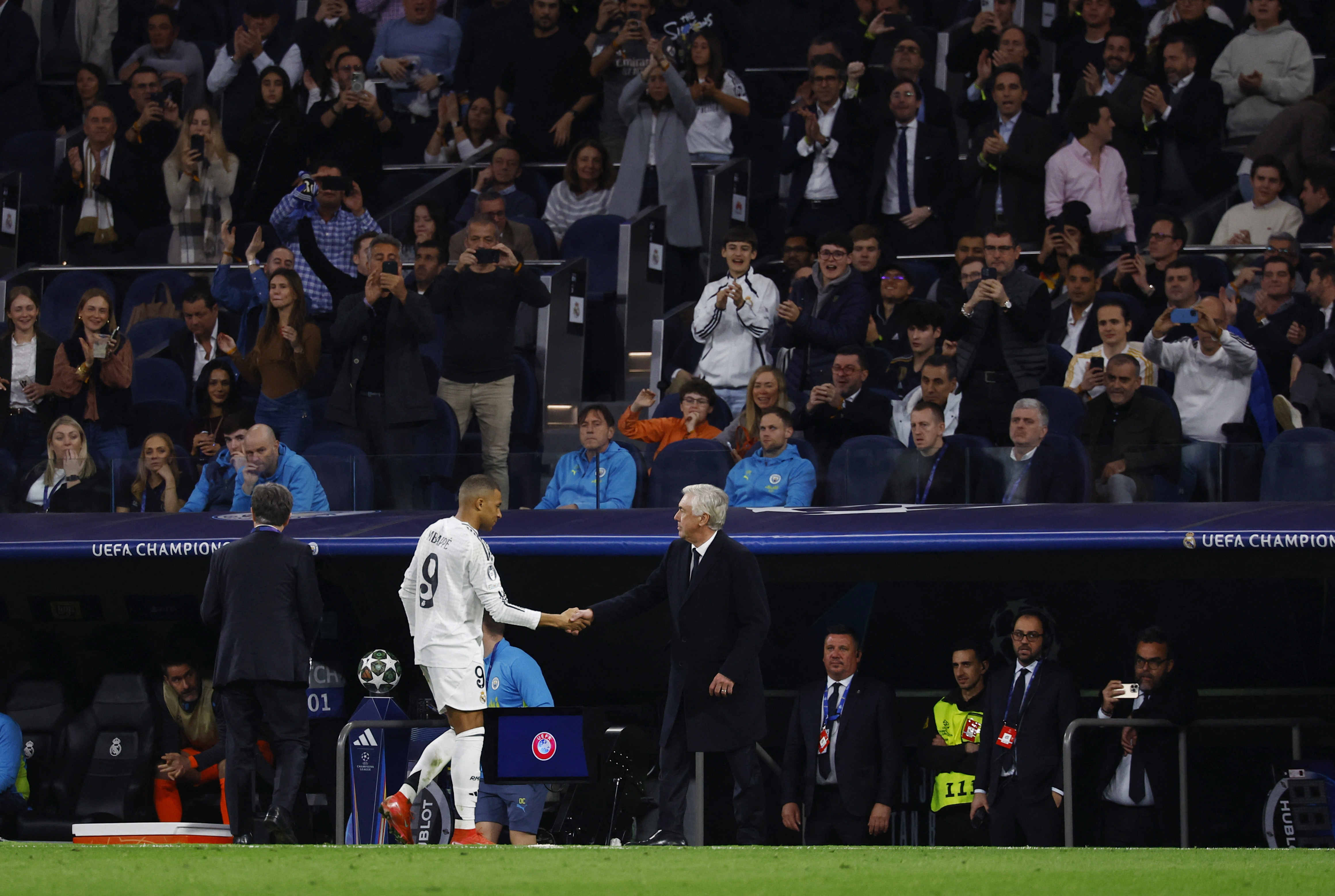 Soccer Football - Champions League - Knockout Phase Playoff - Second Leg - Real Madrid v Manchester City - Santiago Bernabeu, Madrid, Spain - February 19, 2025 Real Madrid's Kylian Mbappe shakes hands with coach Carlo Ancelotti after being substituted REUTERS/Susana Vera