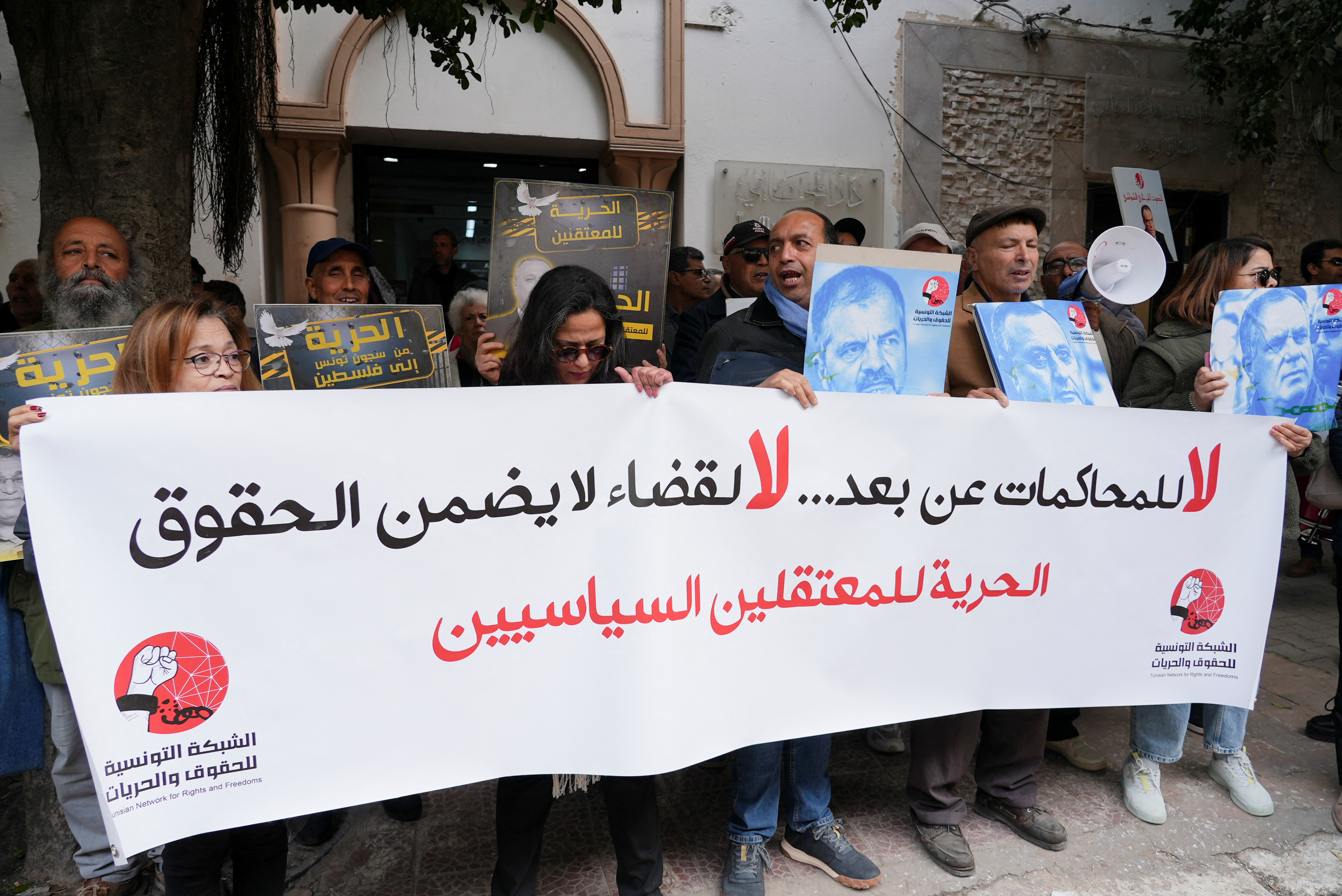 Activists and members of human rights groups hold a banner which says, "No to remote trials, No to a judiciary that does not guarantee rights, Freedom for political detainees"