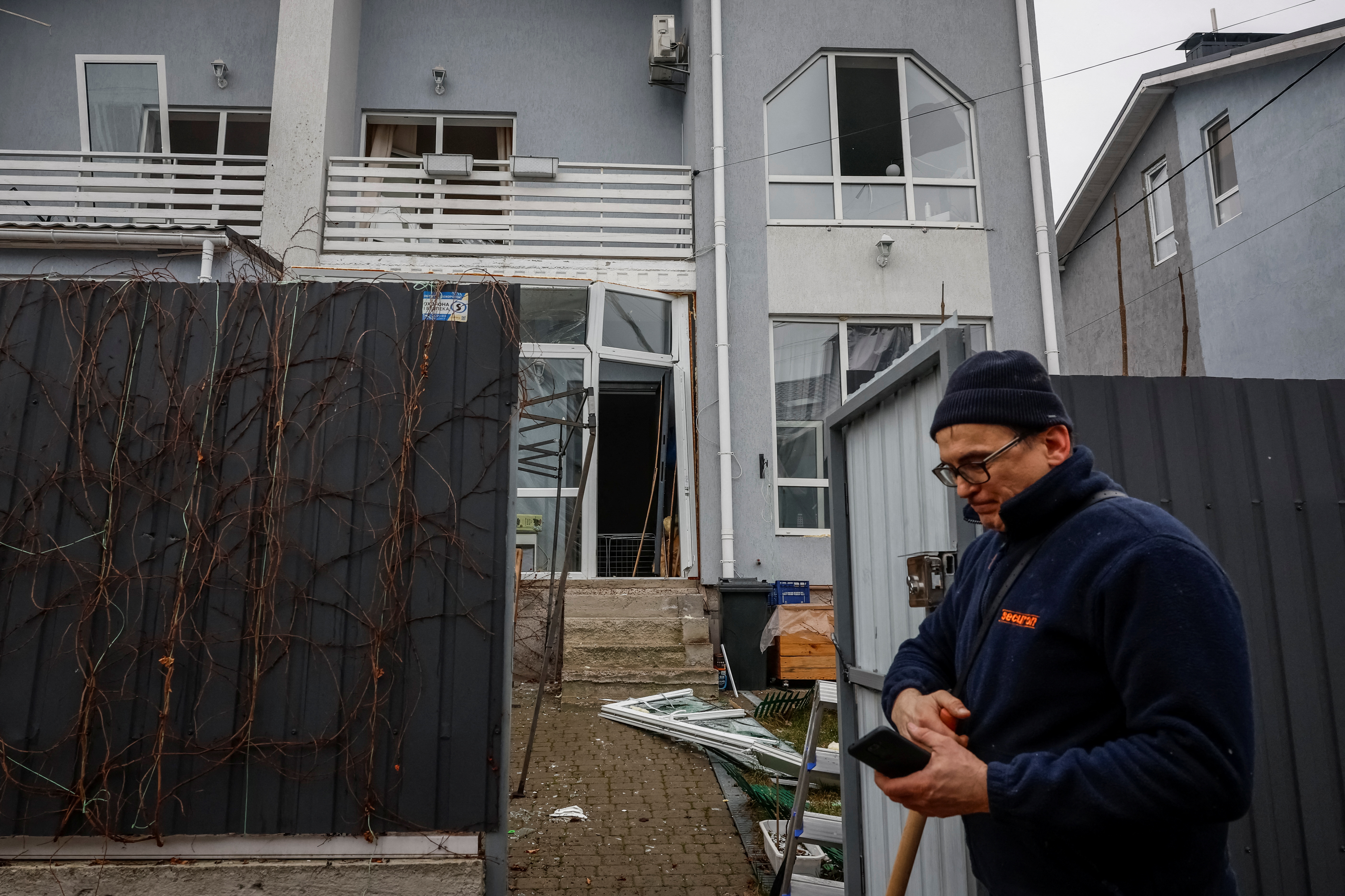 A man clear rubbles near his damaged house at a site of a Russian drone strike, amid Russia's attack on Ukraine, in the town of Hostomel, Kyiv region, Ukraine March 19, 2025. REUTERS/Alina Smutko