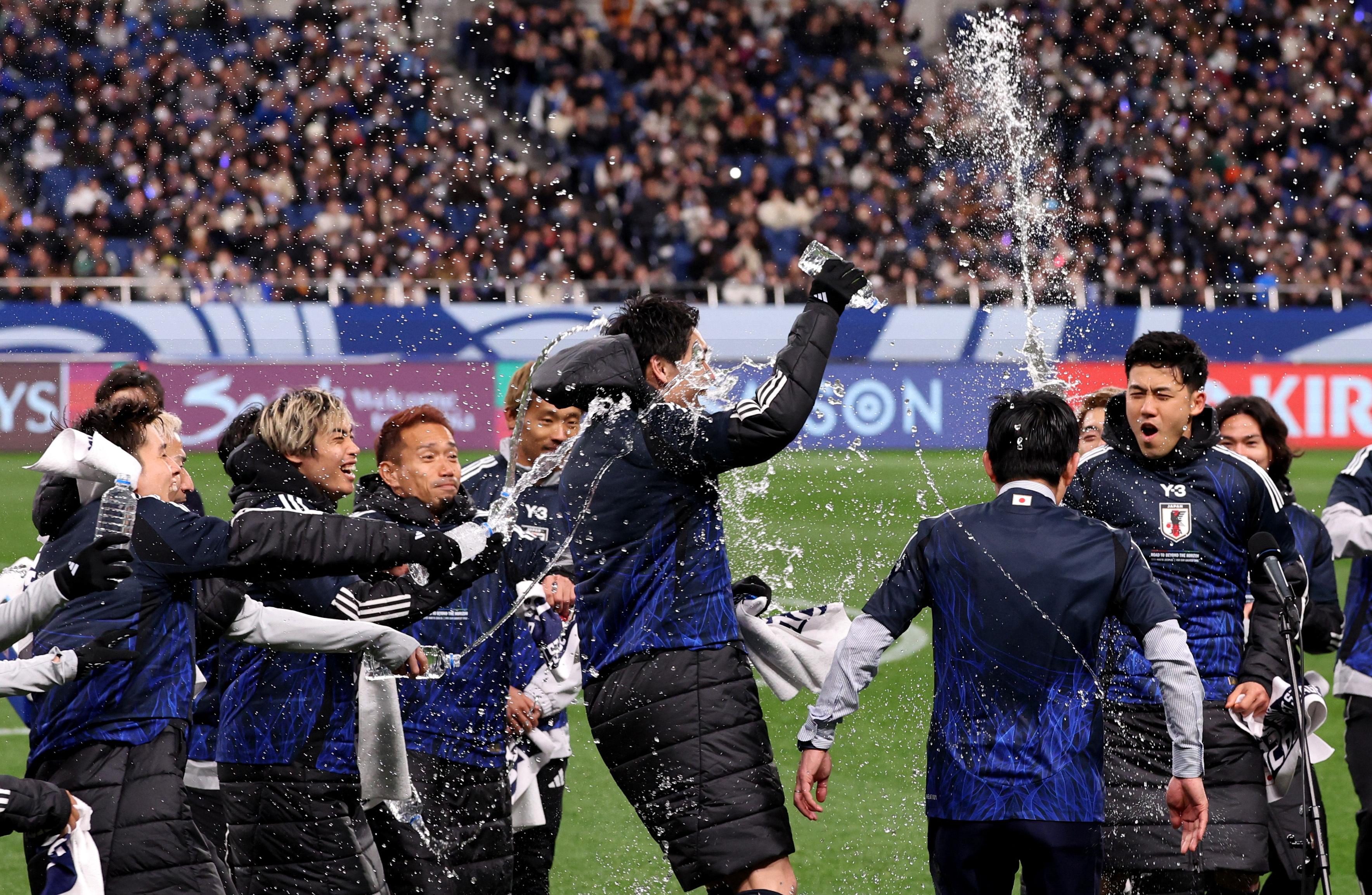 Soccer Football - World Cup - AFC Qualifiers - Third Round - Group C - Japan v Bahrain - Saitama Stadium, Saitama, Japan - March 20, 2025 Japan players celebrate with coach Hajime Moriyasu after qualifying for the 2026 World Cup REUTERS/Kim Kyung-Hoon
