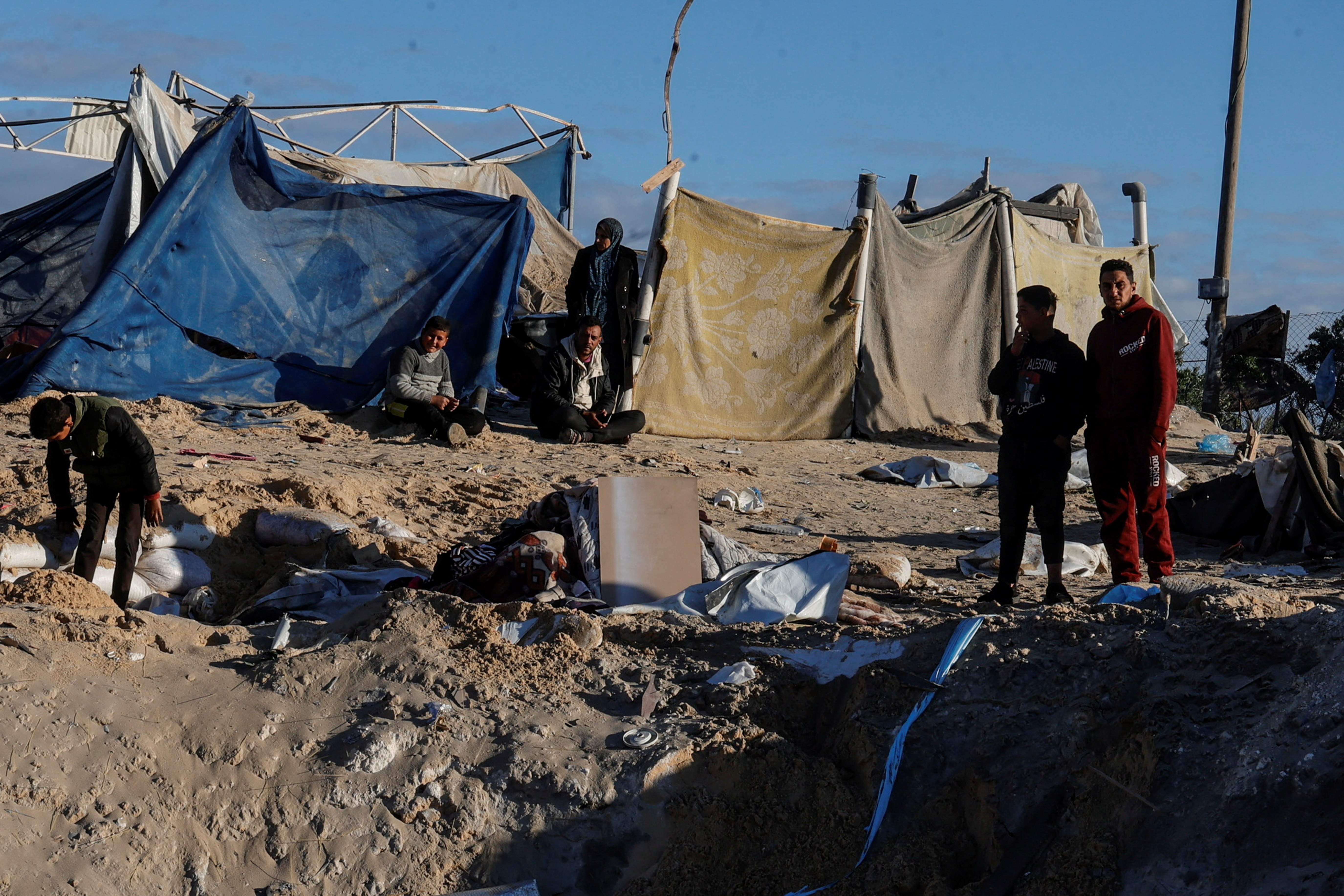 Palestinians gather at the scene where an Israeli strike killed Hamas political leader Salah al-Bardawil and his wife