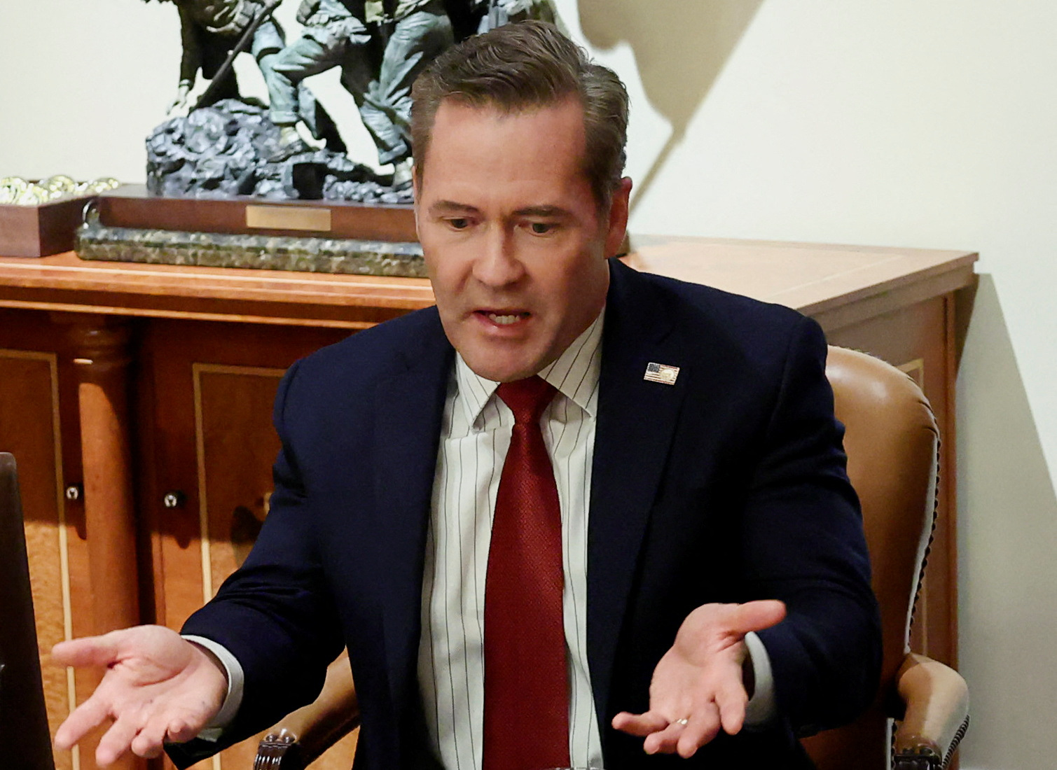 Mike Waltz shrugs with his palms upturned at a meeting in the White House