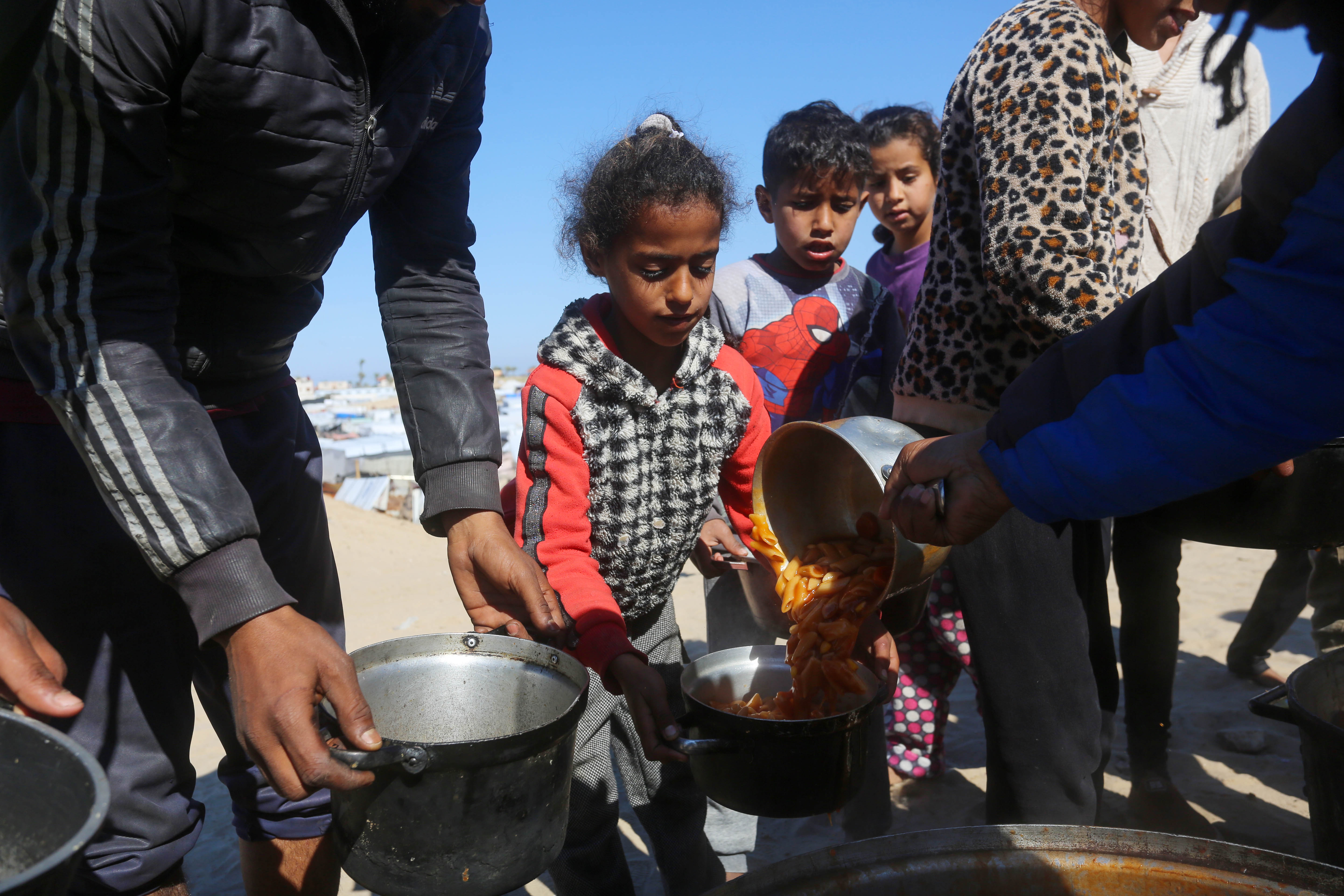 Displaced Palestinians receive food aid in southern Gaza