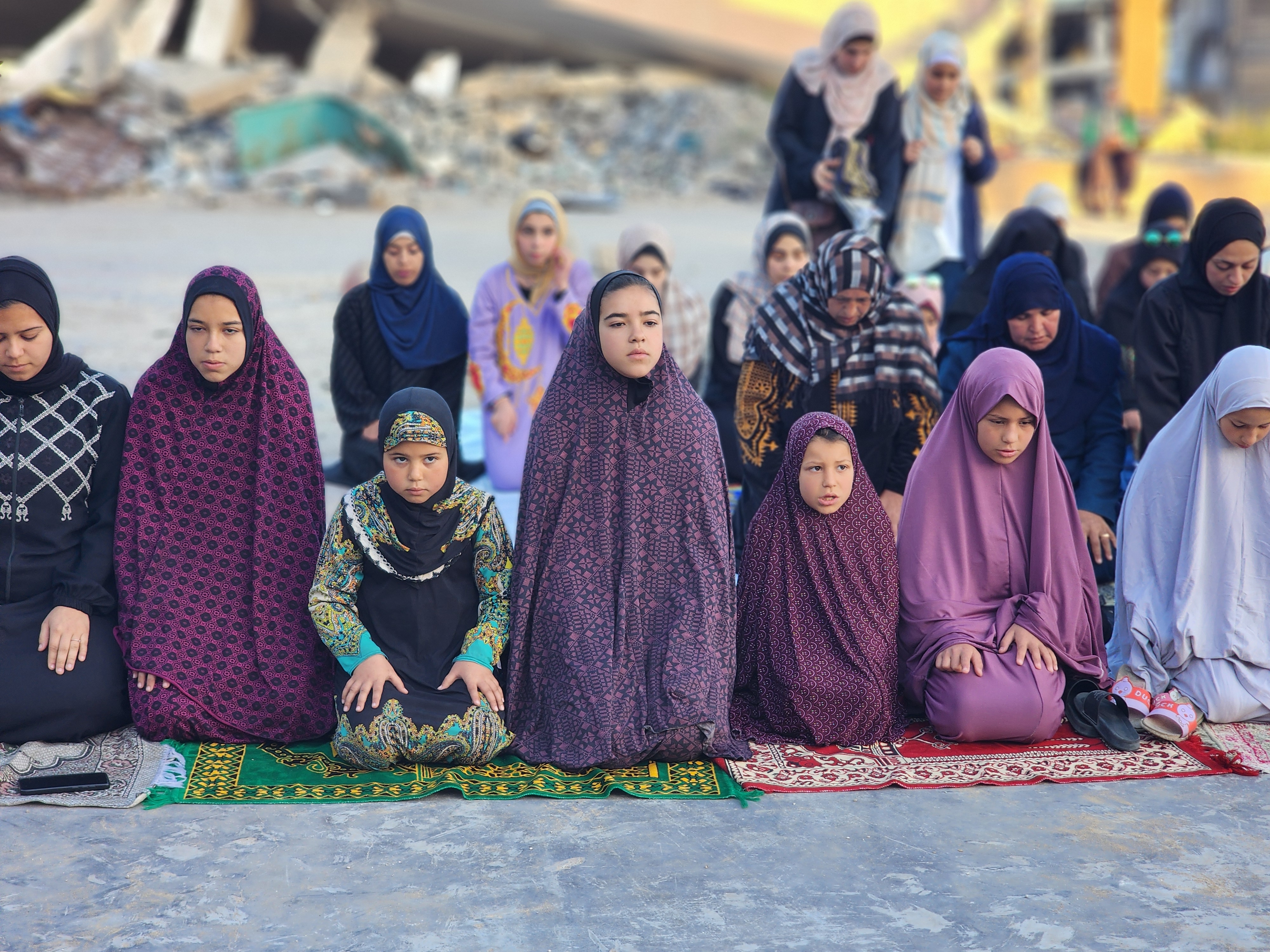 Displaced Palestinians gather at the courtyard of the Martyrs' School to perform Eid al-Fitr prayers.