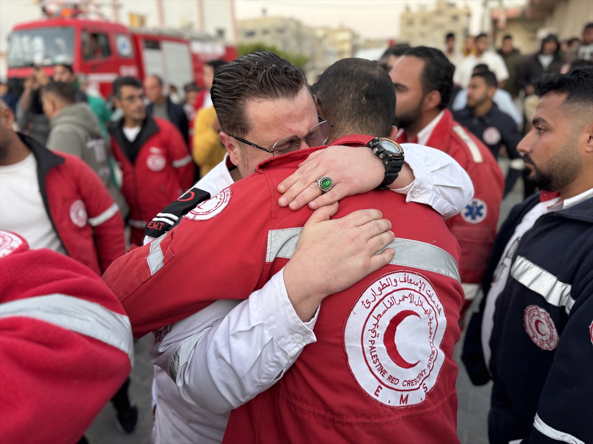 people wearing red and white uniforms gather around bodies and embrace each other