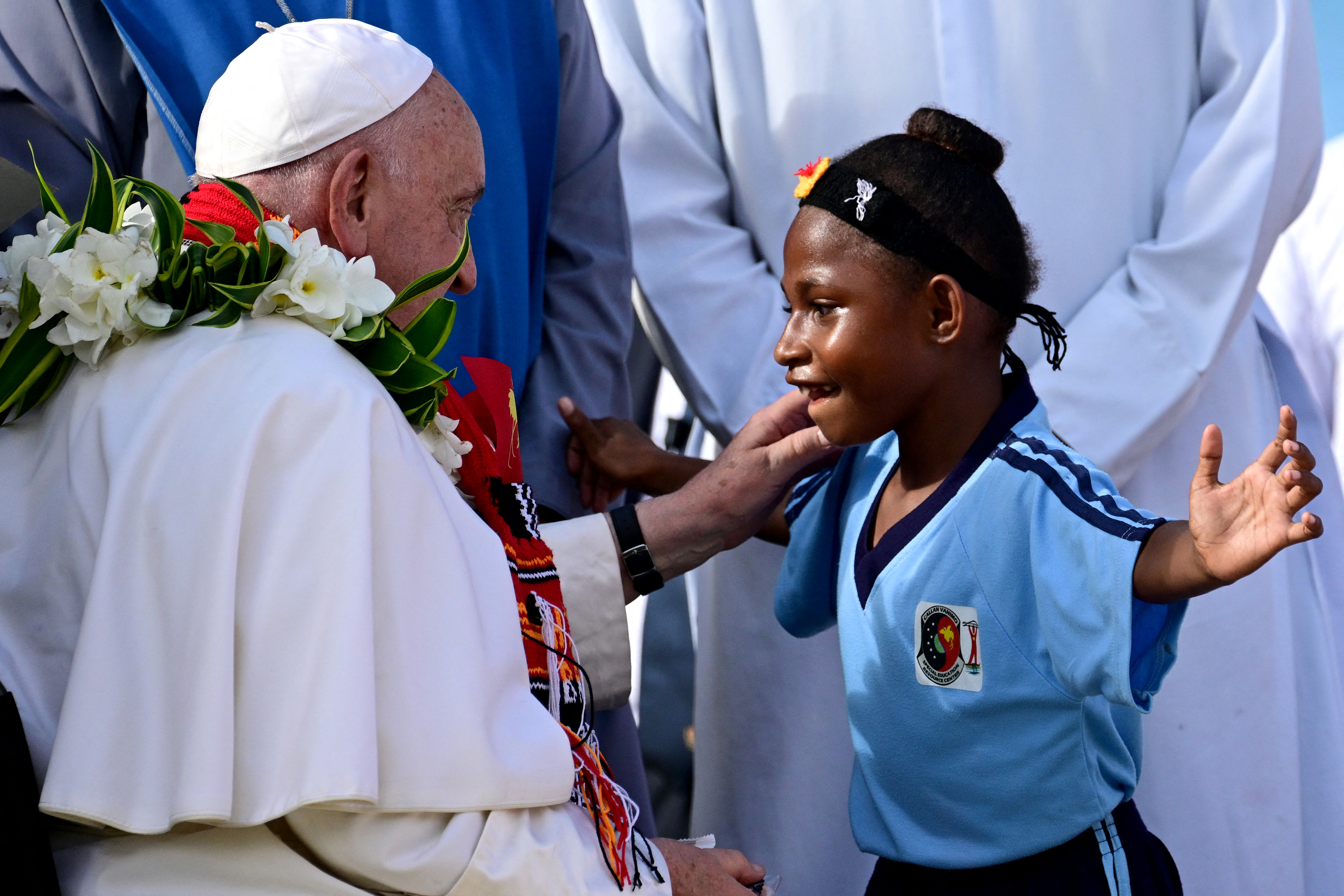 Pope Francis greets a child during a visit to a school.