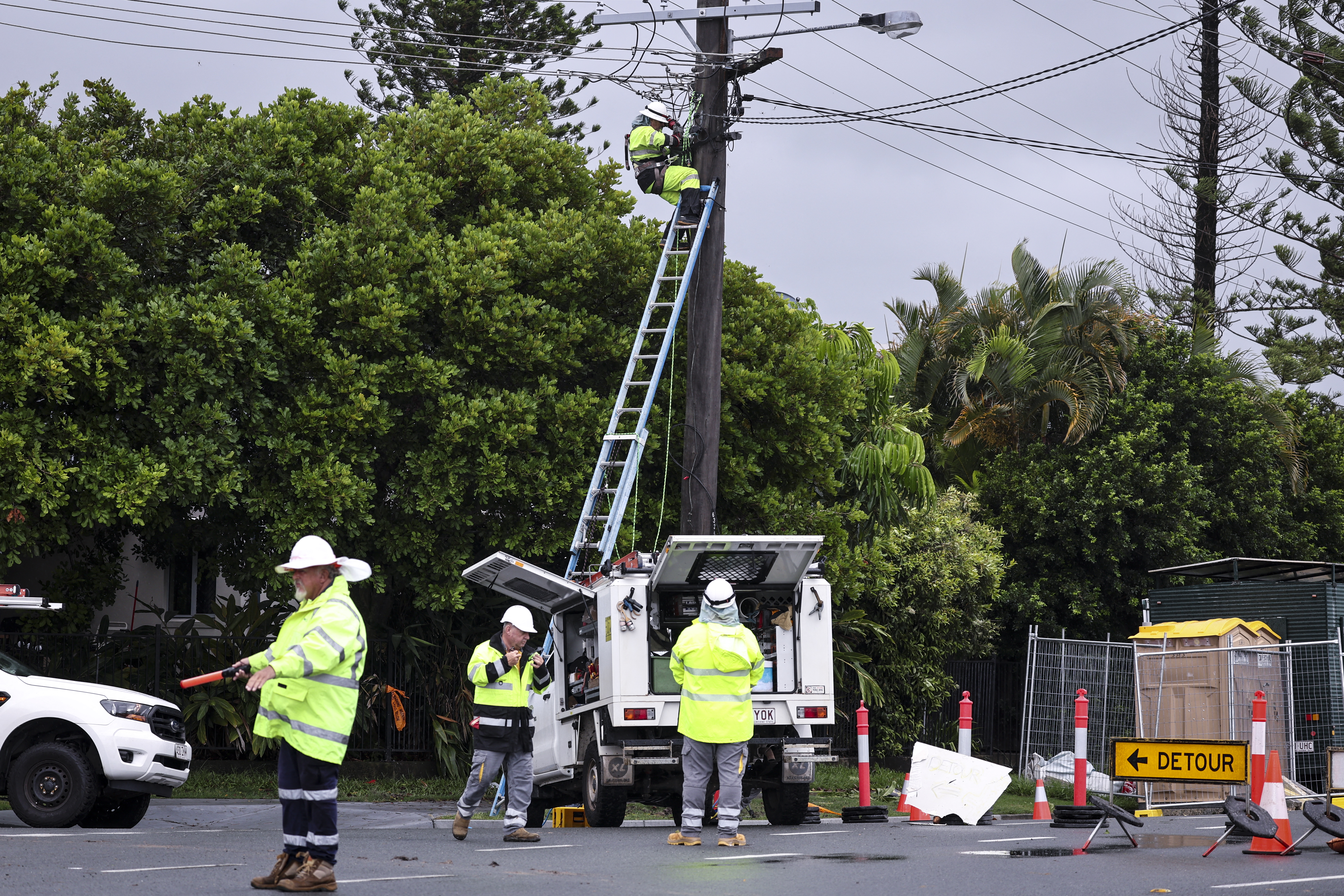 Workers fix electricity wires that were damaged due to strong winds from Cyclone Alfred in the suburb of Elanora on the Gold Coast on March 8, 2025. Cyclone Alfred weakened into a tropical low on March 8 but still threatened to unleash major floods on swollen rivers as it approached the rain and wind-lashed eastern coast of Australia
