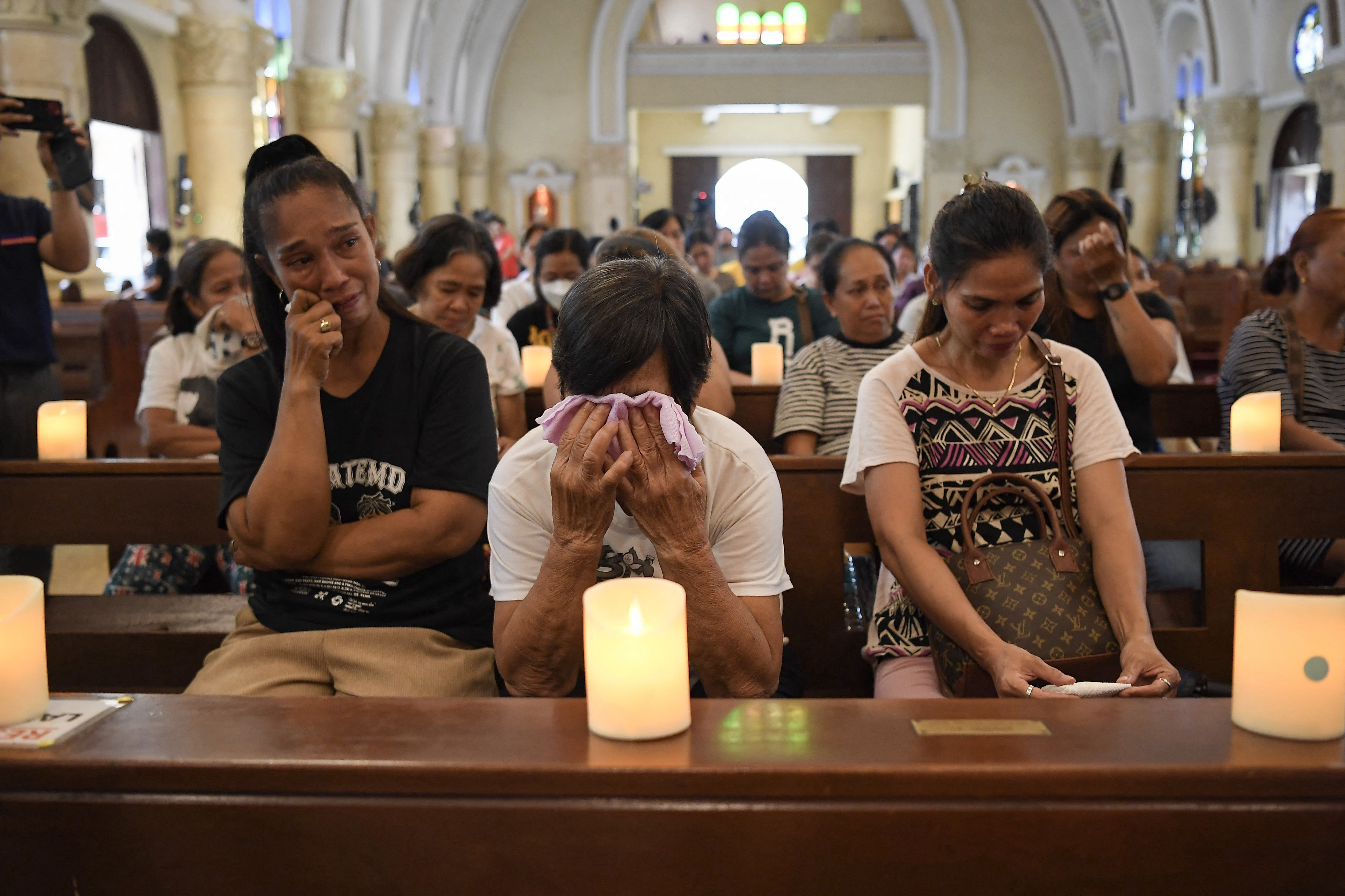 Relatives of victims of former Philippine president Rodrigo Duterte's war on drugs cry during a mass for victims at a church in Manila on March 11, 2025. Former Philippines president Rodrigo Duterte was arrested on March 11 in Manila by police acting on an International Criminal Court warrant tied to his deadly war on drugs. (Photo by TED ALJIBE / AFP)