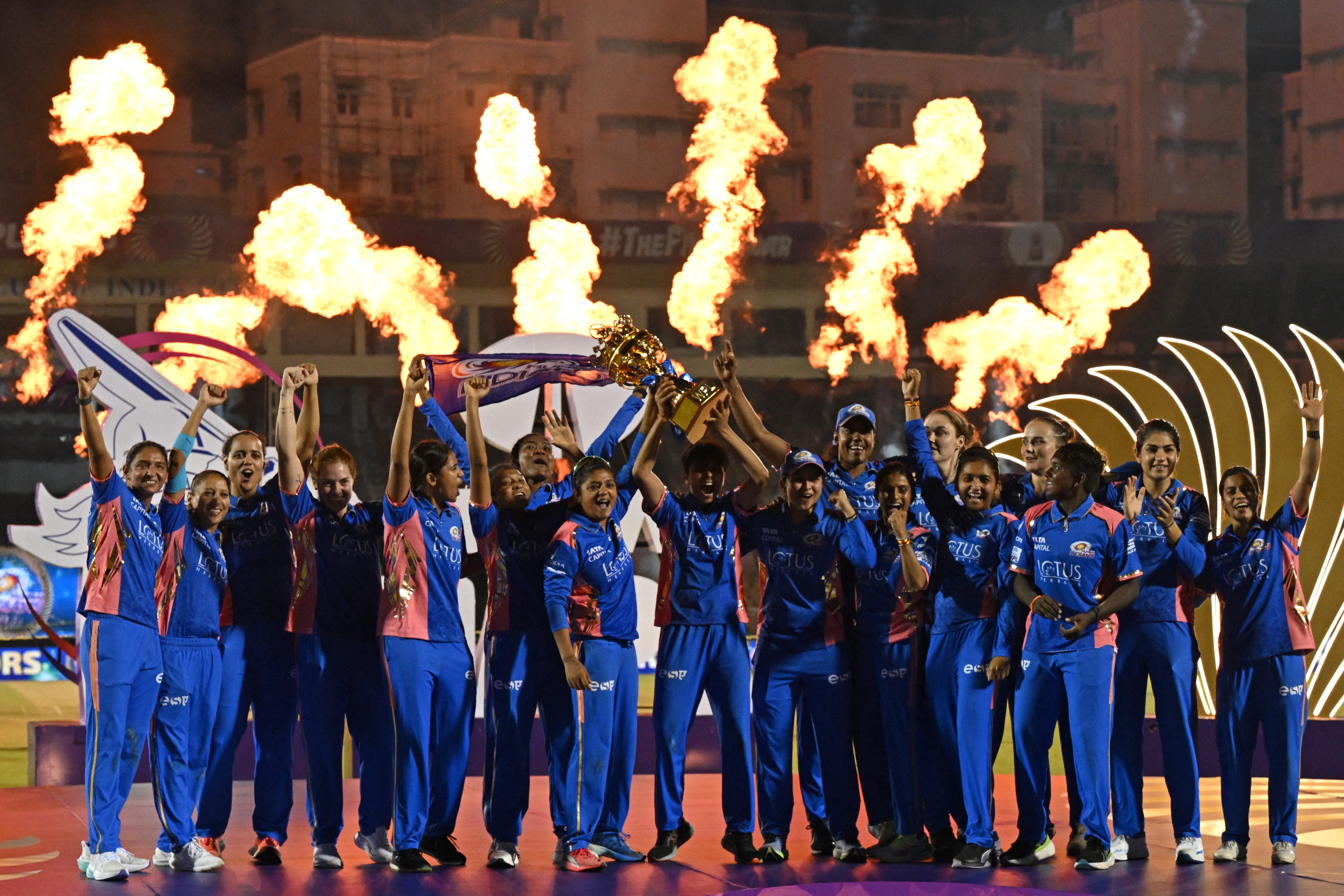Mumbai Indians players celebrate with the winning trophy at the end of the Women's Premier League (WPL) Twenty20 final cricket match between Mumbai Indians and Delhi Capitals at Brabourne Stadium in Mumbai on March 16, 2025. (Photo by INDRANIL MUKHERJEE / AFP) / -- IMAGE RESTRICTED TO EDITORIAL USE - STRICTLY NO COMMERCIAL USE --