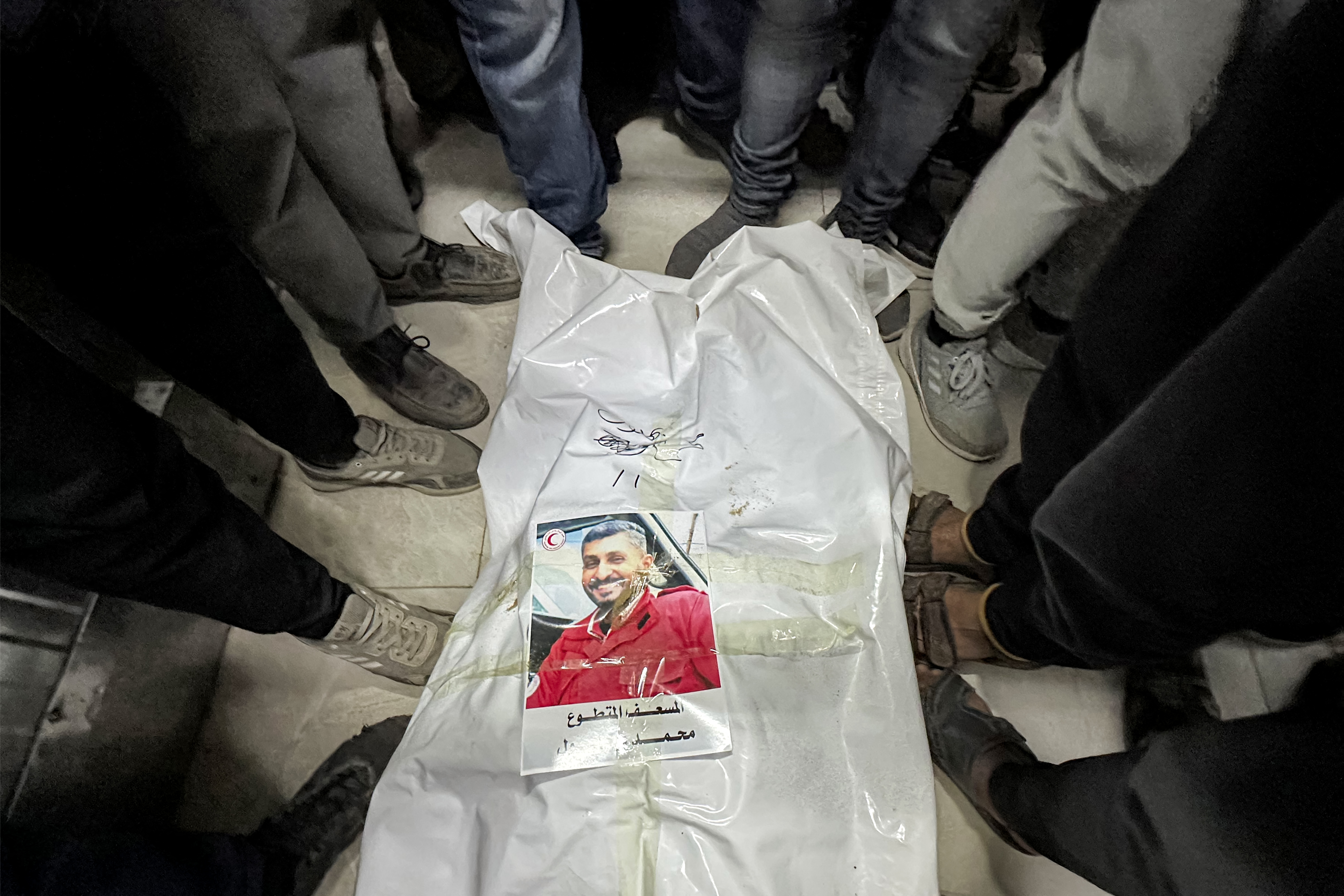 People gather around the body of Palestinian paramedic Mohamed Bahloul.