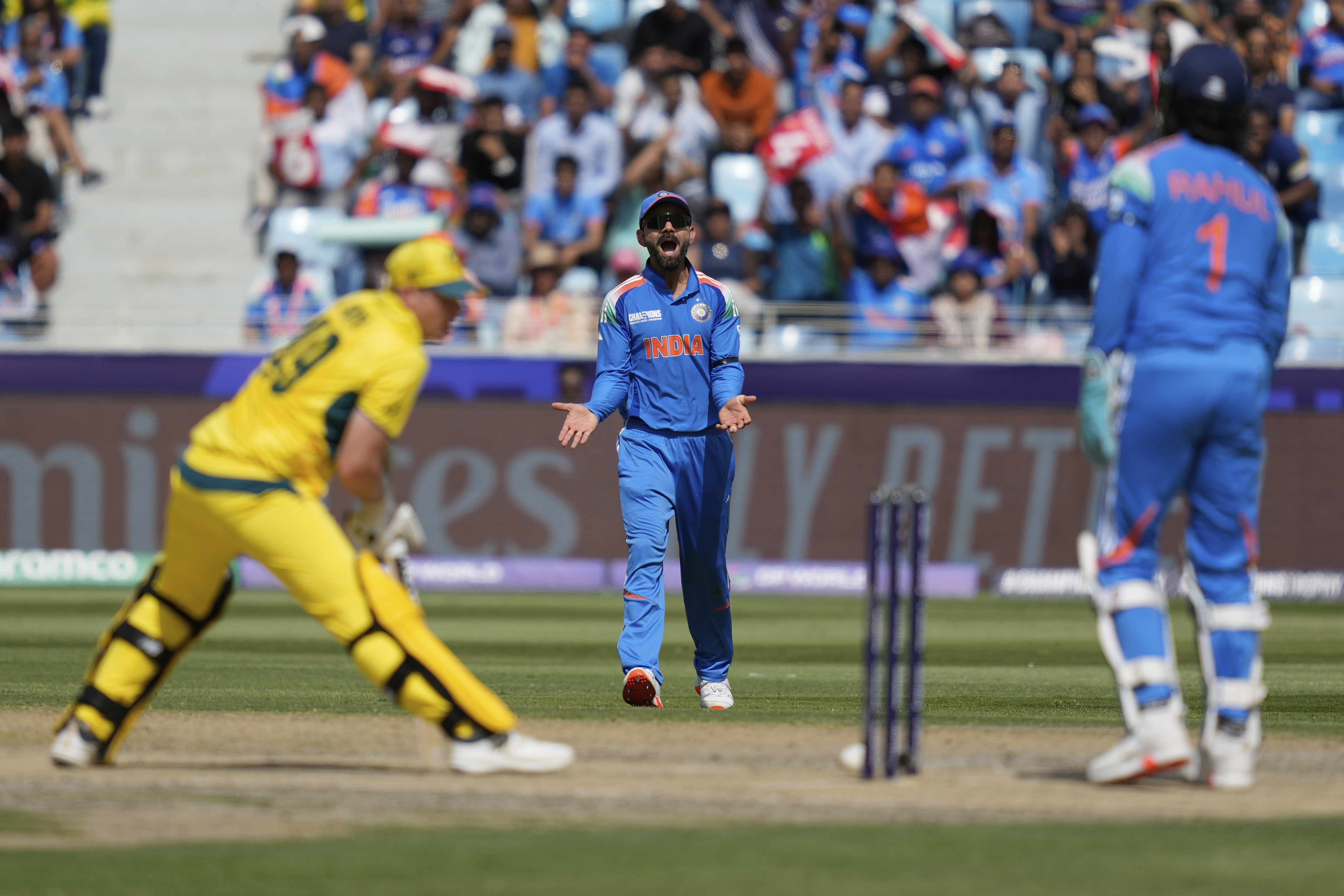 India's Virat Kohli reacts as Australia's captain Steve Smith, left, bats during the ICC Champions Trophy semifinal cricket match between India and Australia at Dubai International Cricket Stadium in Dubai, United Arab Emirates, Tuesday, March 4, 2025. (AP Photo/Altaf Qadri)