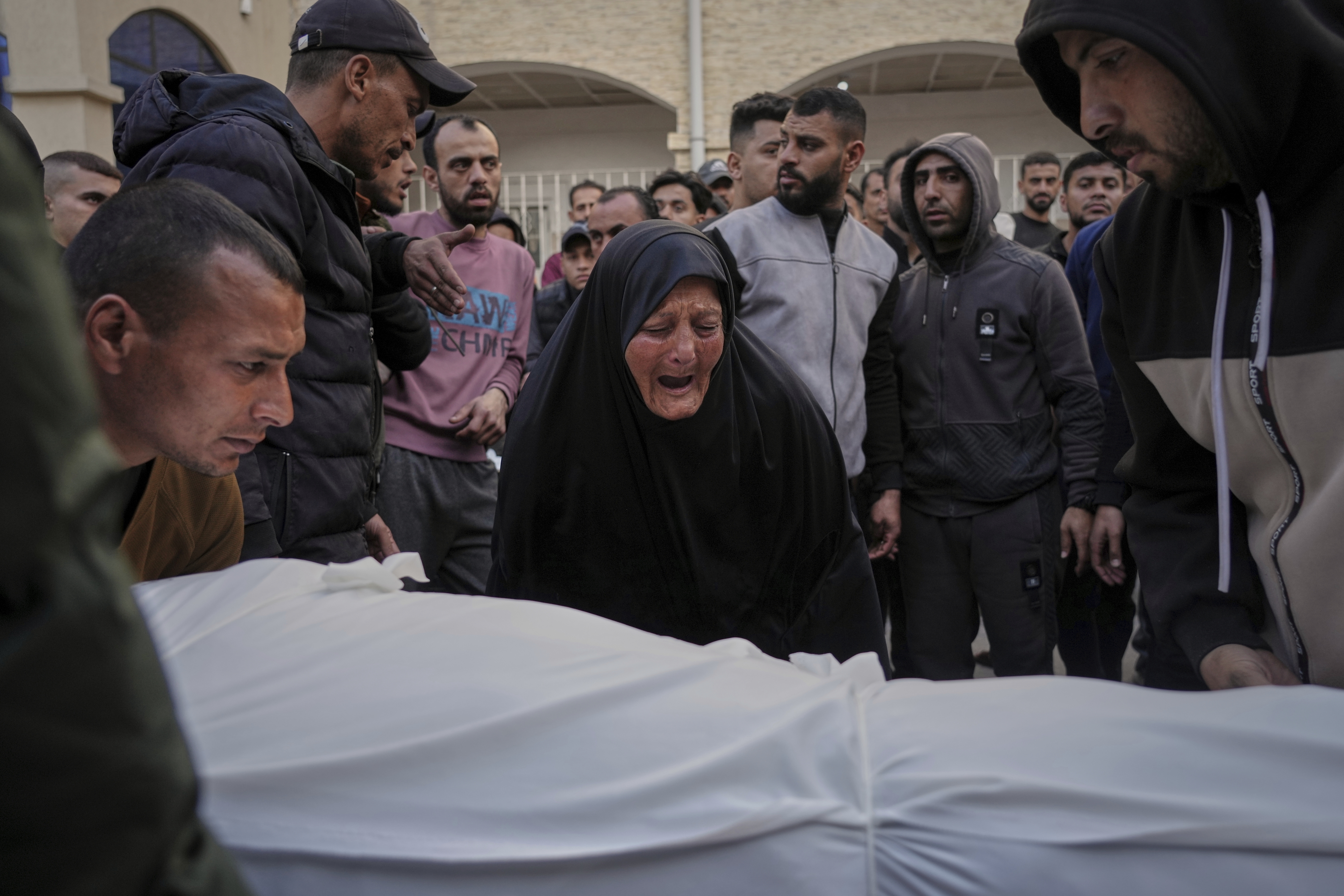 A woman reacts over the body of a person killed during overnight Israeli army airstrikes across the Gaza Strip, at the Al-Ahli hospital in Gaza City, Tuesday
