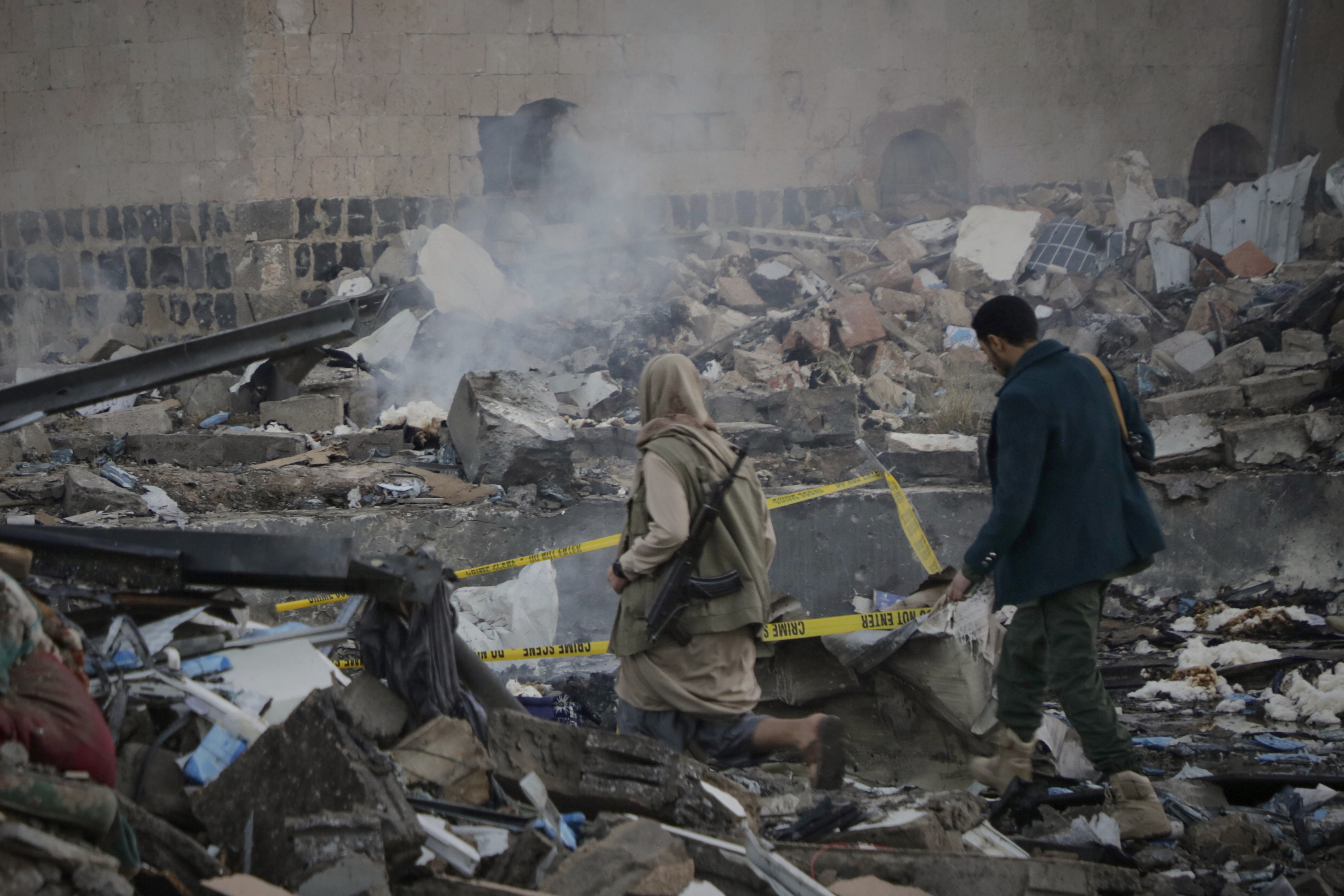 A person walks through rubble in Sanaa after a US strike
