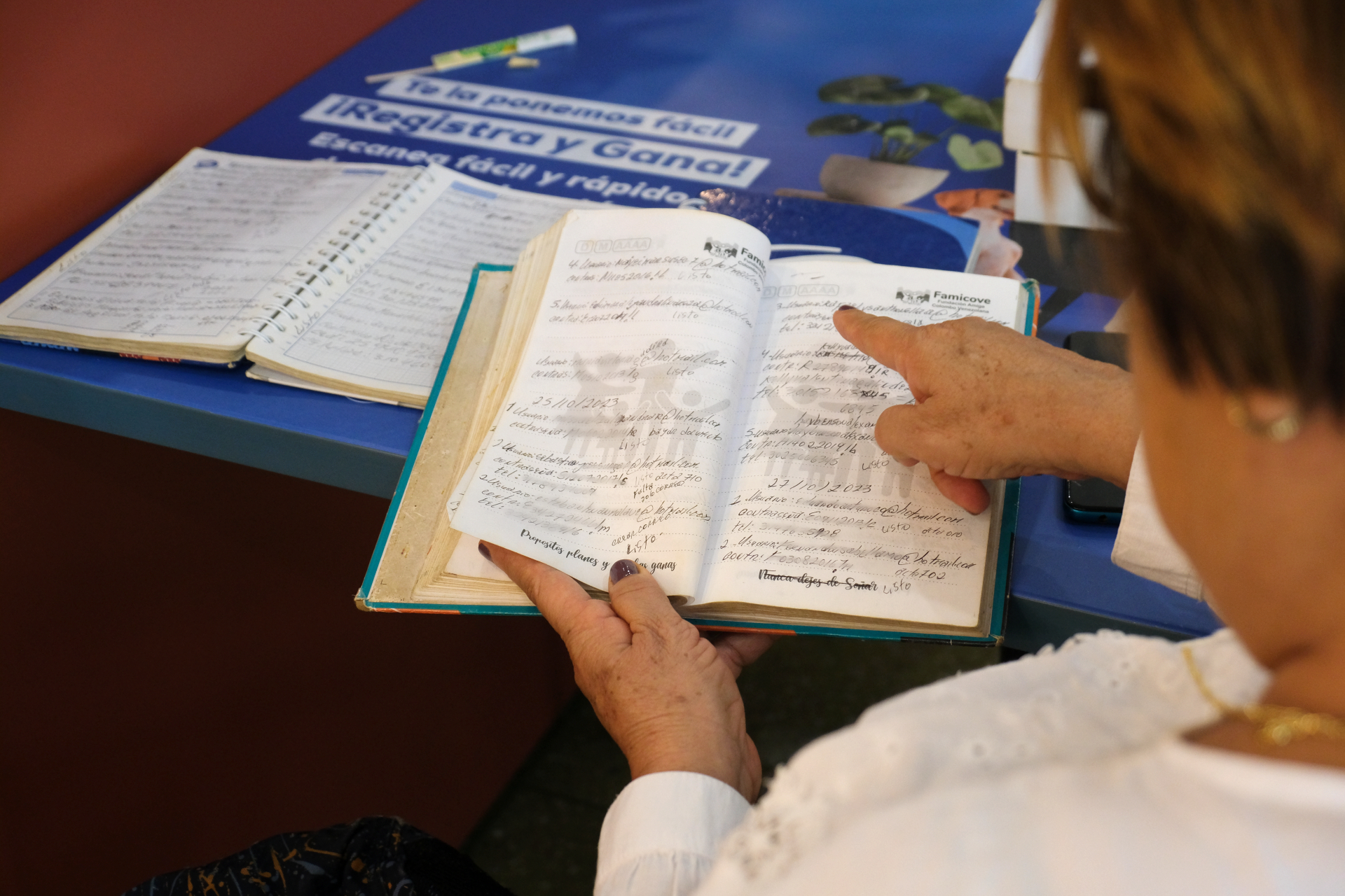 Adriana Llano Medina points to handwritten notes in a book.