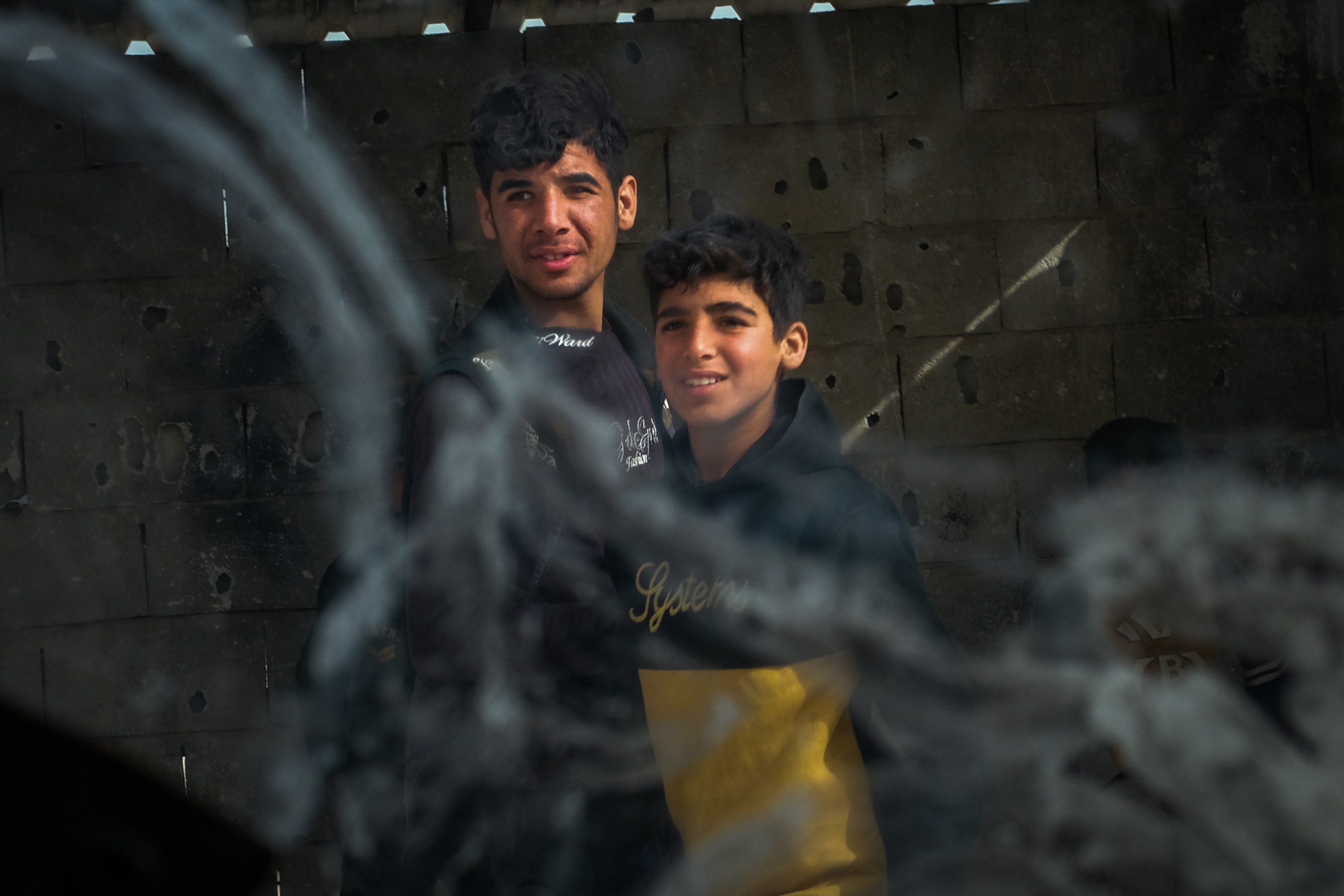 Two boys walk past a security patrol