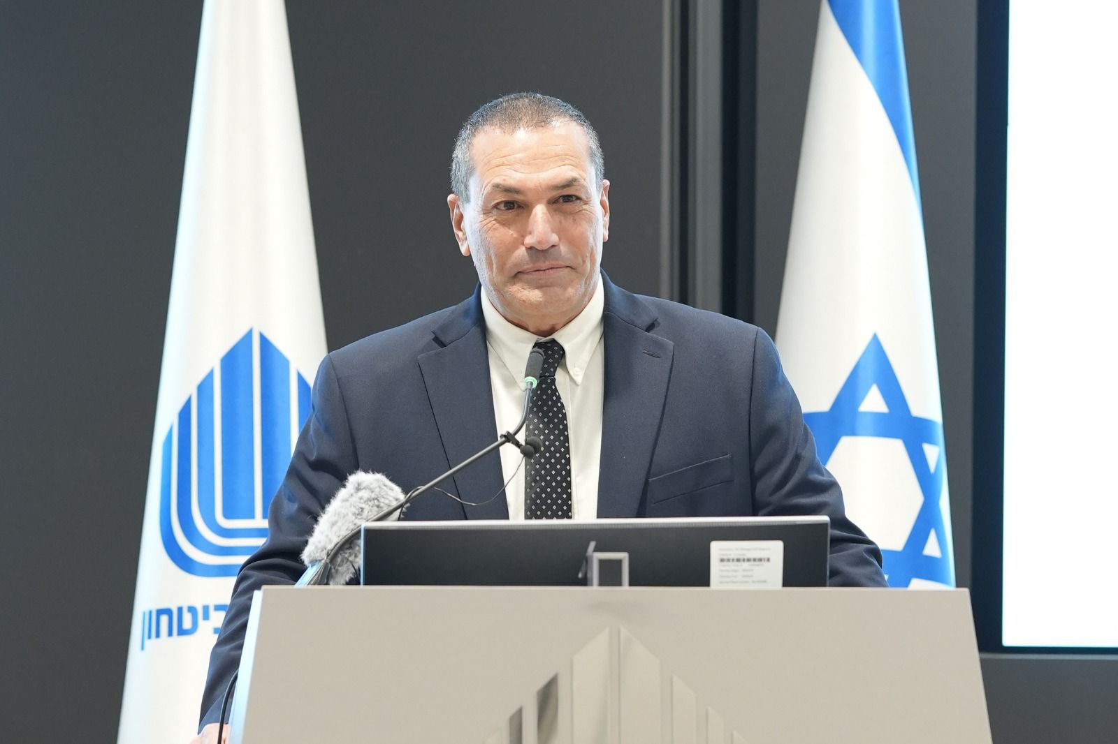 Eyal Zamir speaking at a podium