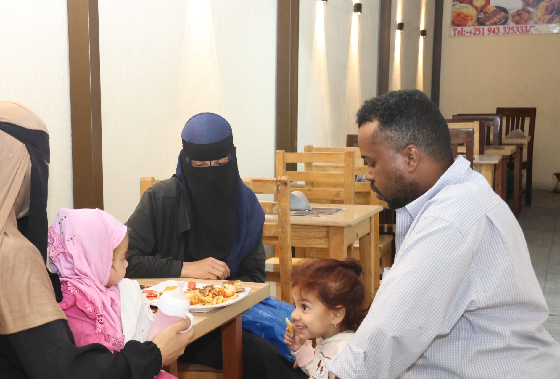 Salem Berhanu, a regular at Syrian restaurants in Bole Michael, enjoying dinner with Syrians [Samuel Getachew/Al Jazeera]