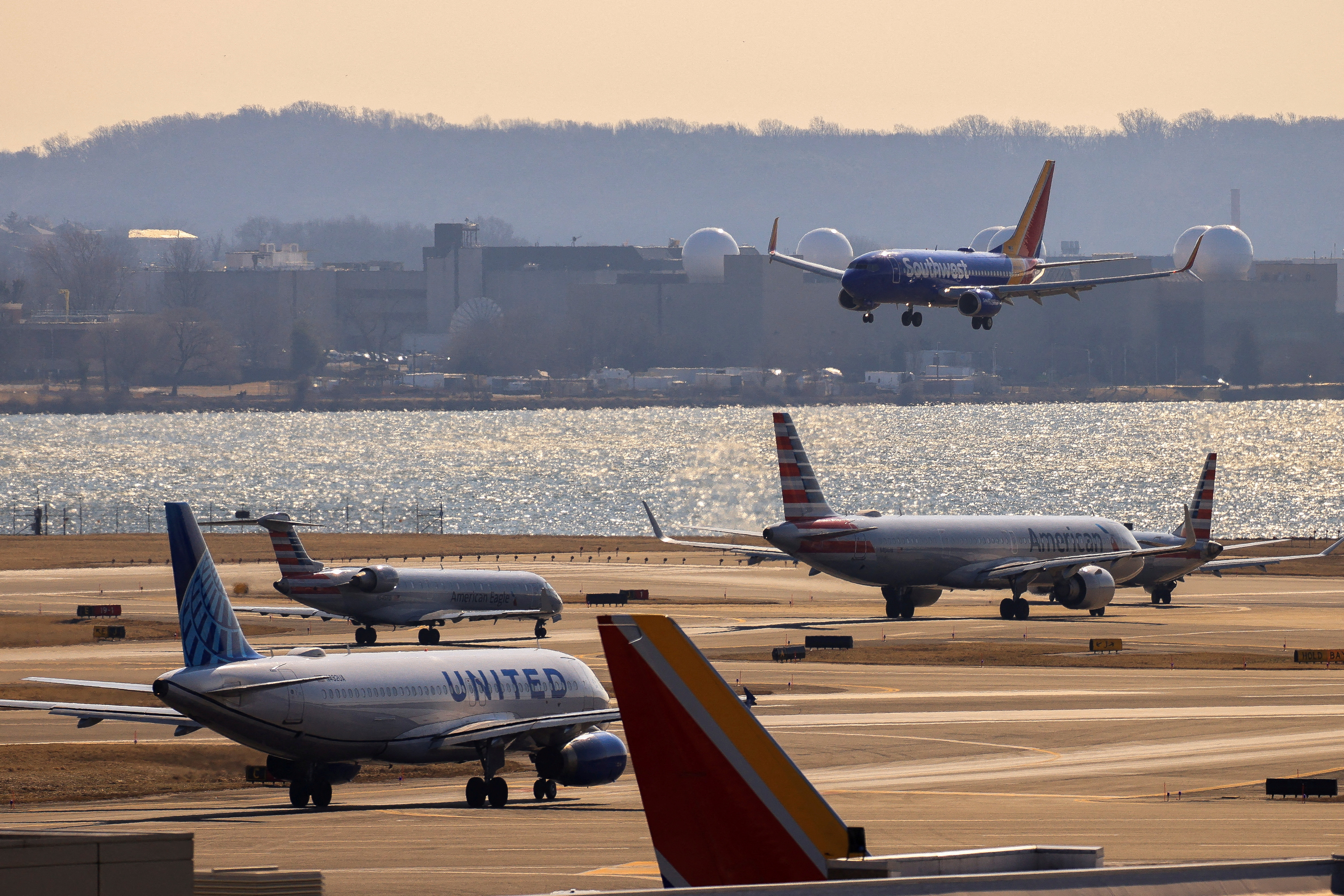 FILE PHOTO: A plane prepares to land as other planes wait their turn in a busy runway at the Ronald Reagan Washington National Airport in Arlington, Virginia, U.S., February 4, 2025. REUTERS/Eduardo Munoz/File Photo
