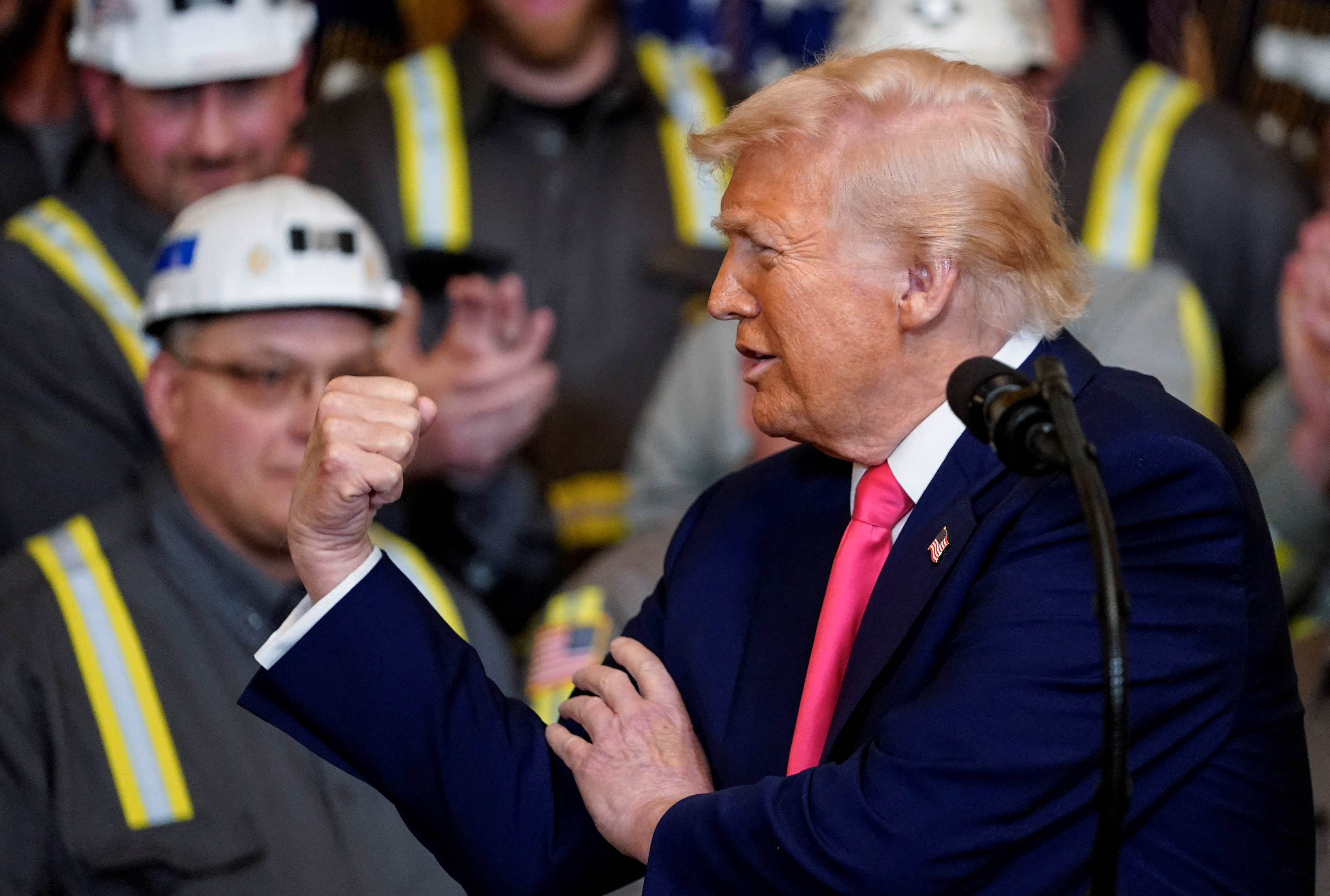 Donald Trump flexes his arm in front of an audience of coal miners in the White House.