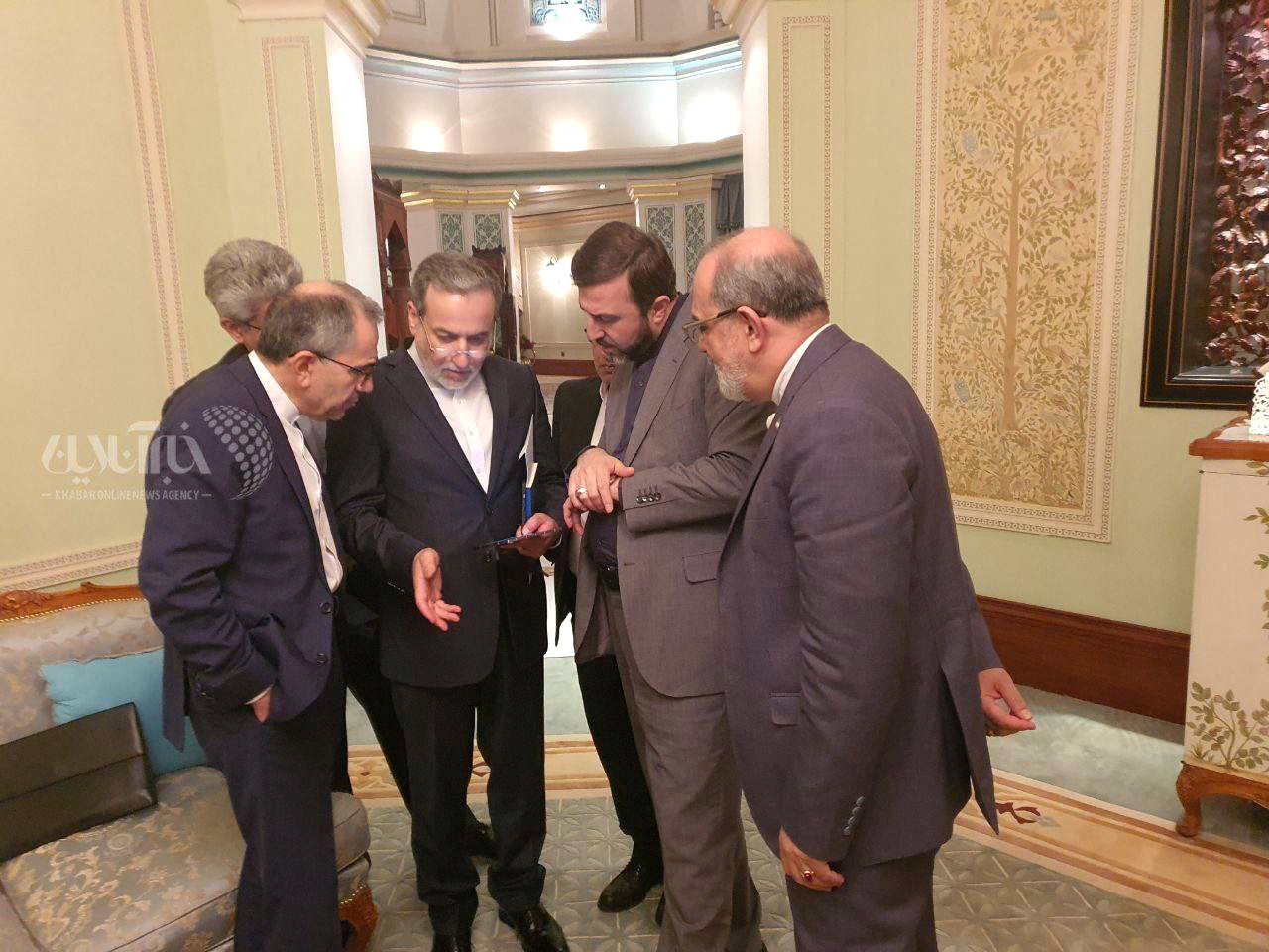Iran's Foreign Minister Abbas Araqchi speaks with the members of the Iranian delegation after the negotiation in Muscat