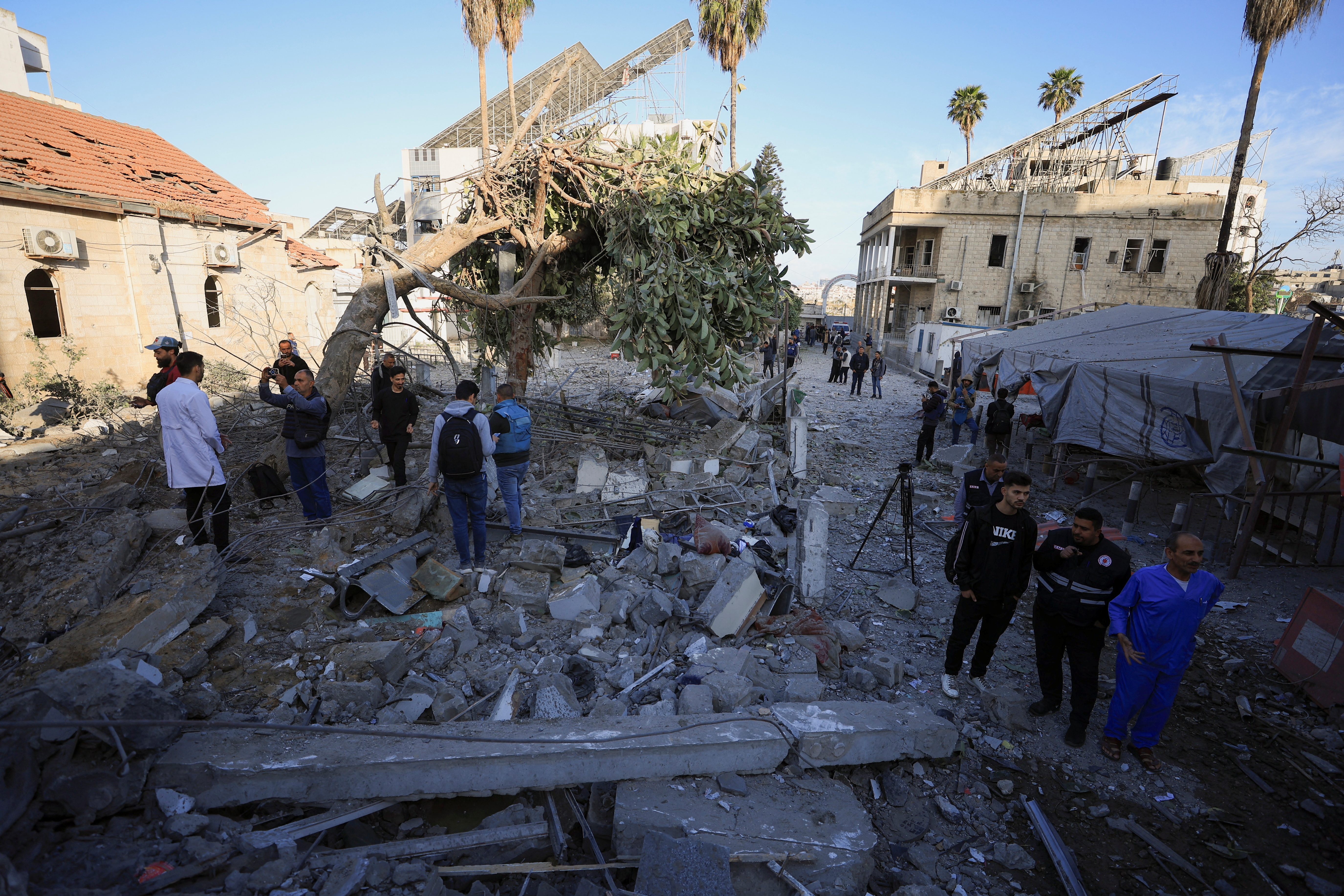 people wearing uniforms stand in the ruins of a destroyed building