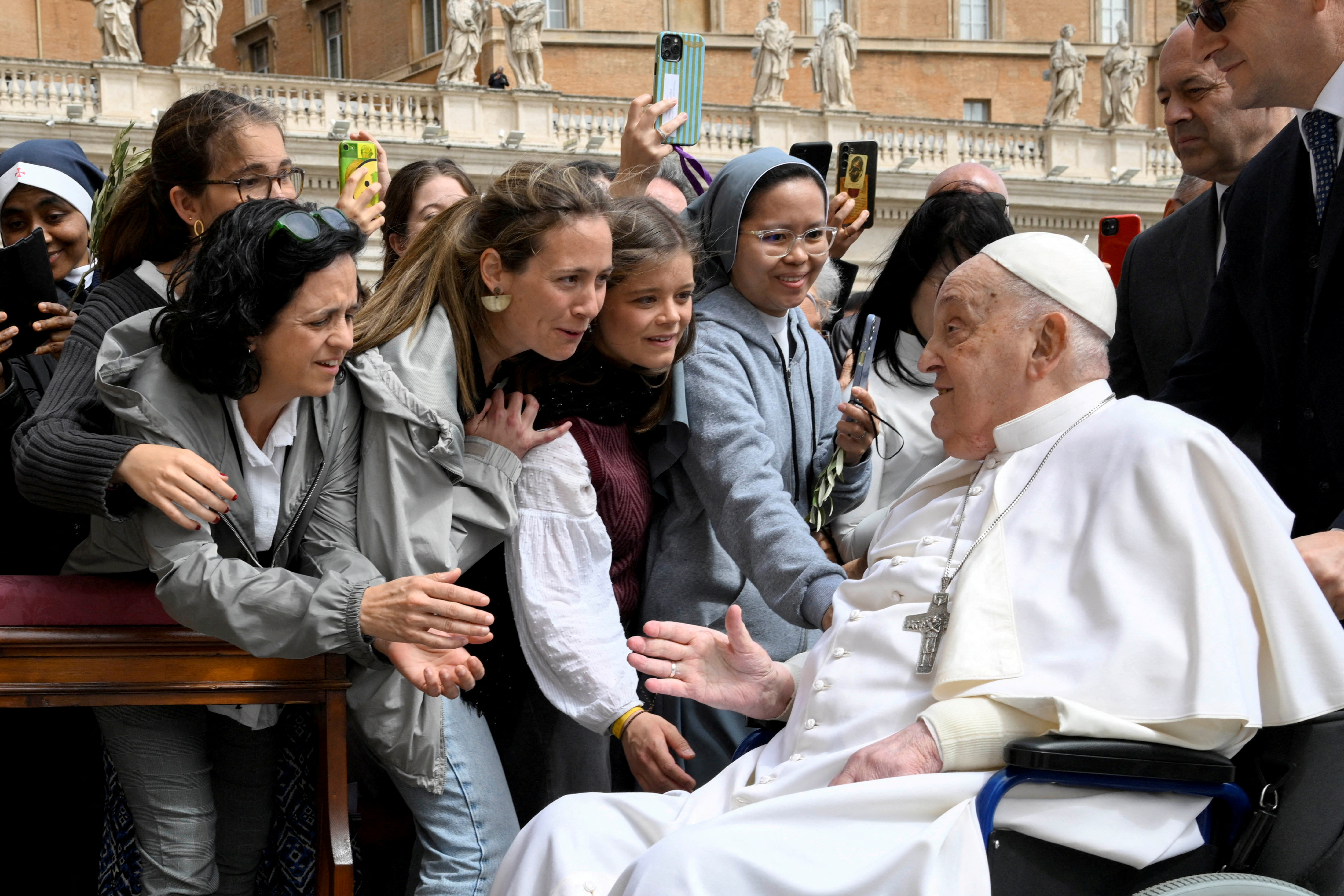 Pope Francis meets with people as he unexpectedly appears during the Palm Sunday Mass