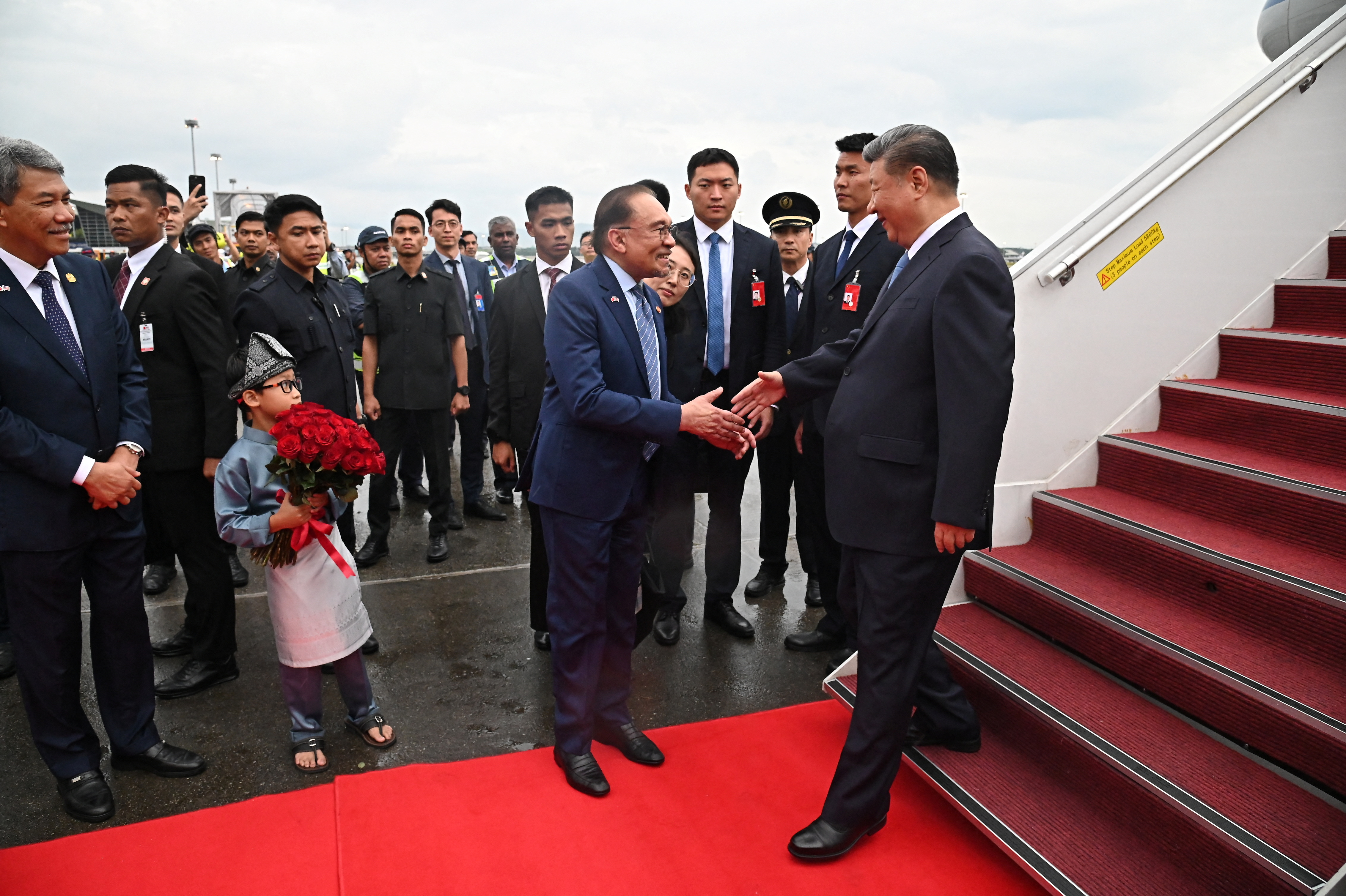 Chinese President Xi Jinping shakes hand with Malaysian Prime Minister Anwar Ibrahim as he arrives for a three-day state visit, at Kuala Lumpur International Airport, in Sepang, Malaysia, April 15, 2025. Farhan Abdullah /Department of Information Malaysia/Handout via REUTERS THIS IMAGE HAS BEEN SUPPLIED BY A THIRD PARTY. MANDATORY CREDIT.