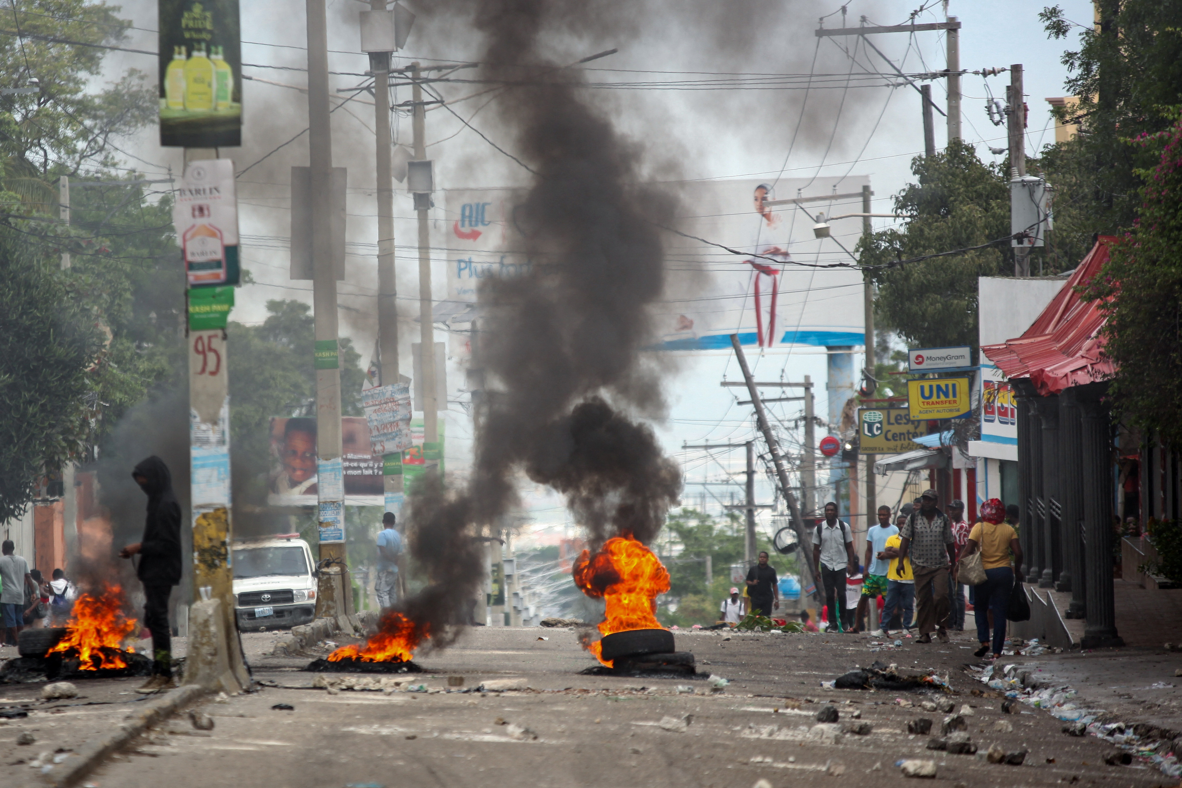 People walk past a burning barricade during a protest in Port-au-Prince, Haiti