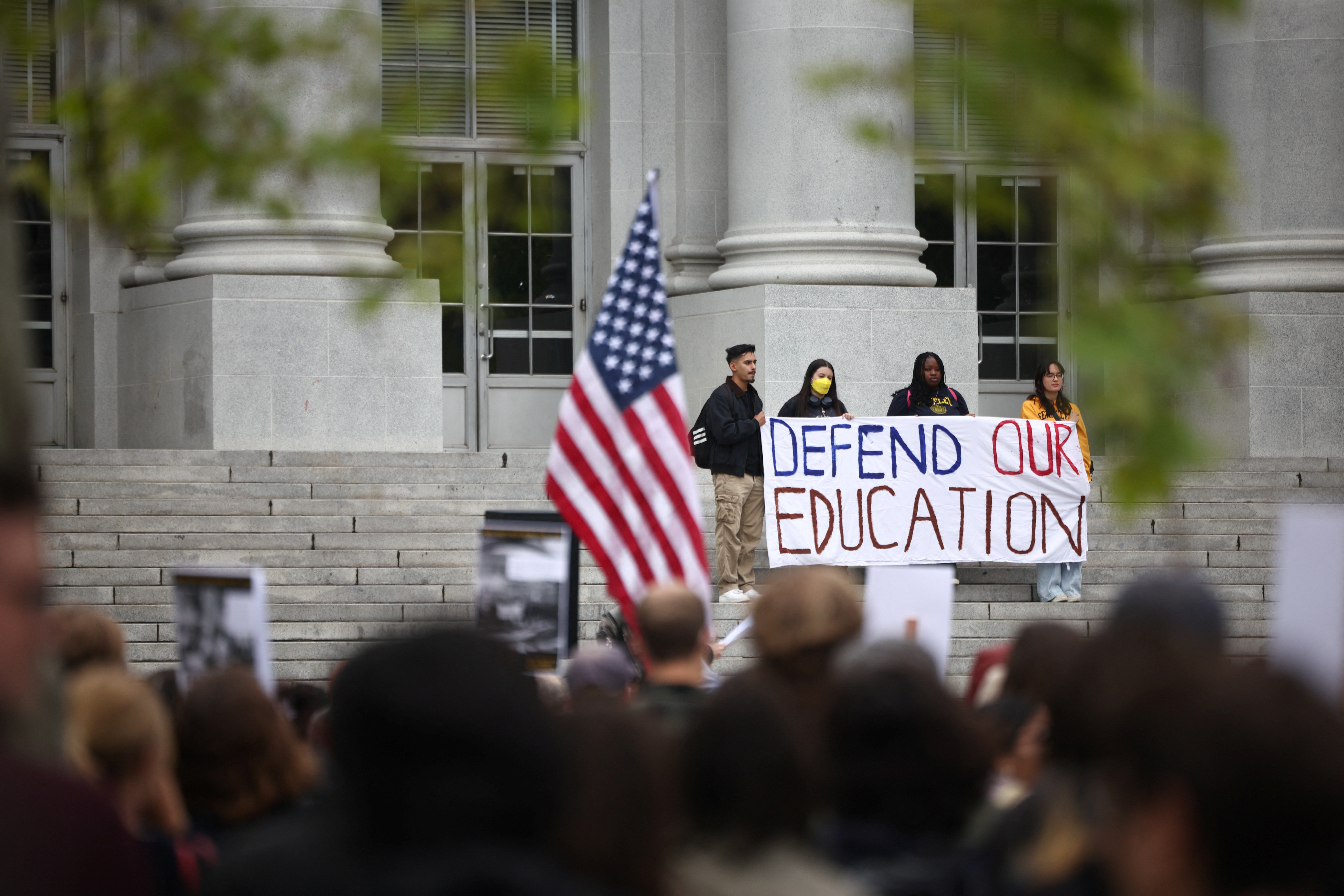 Student protesters hold up a sign that reads "Defend our education"