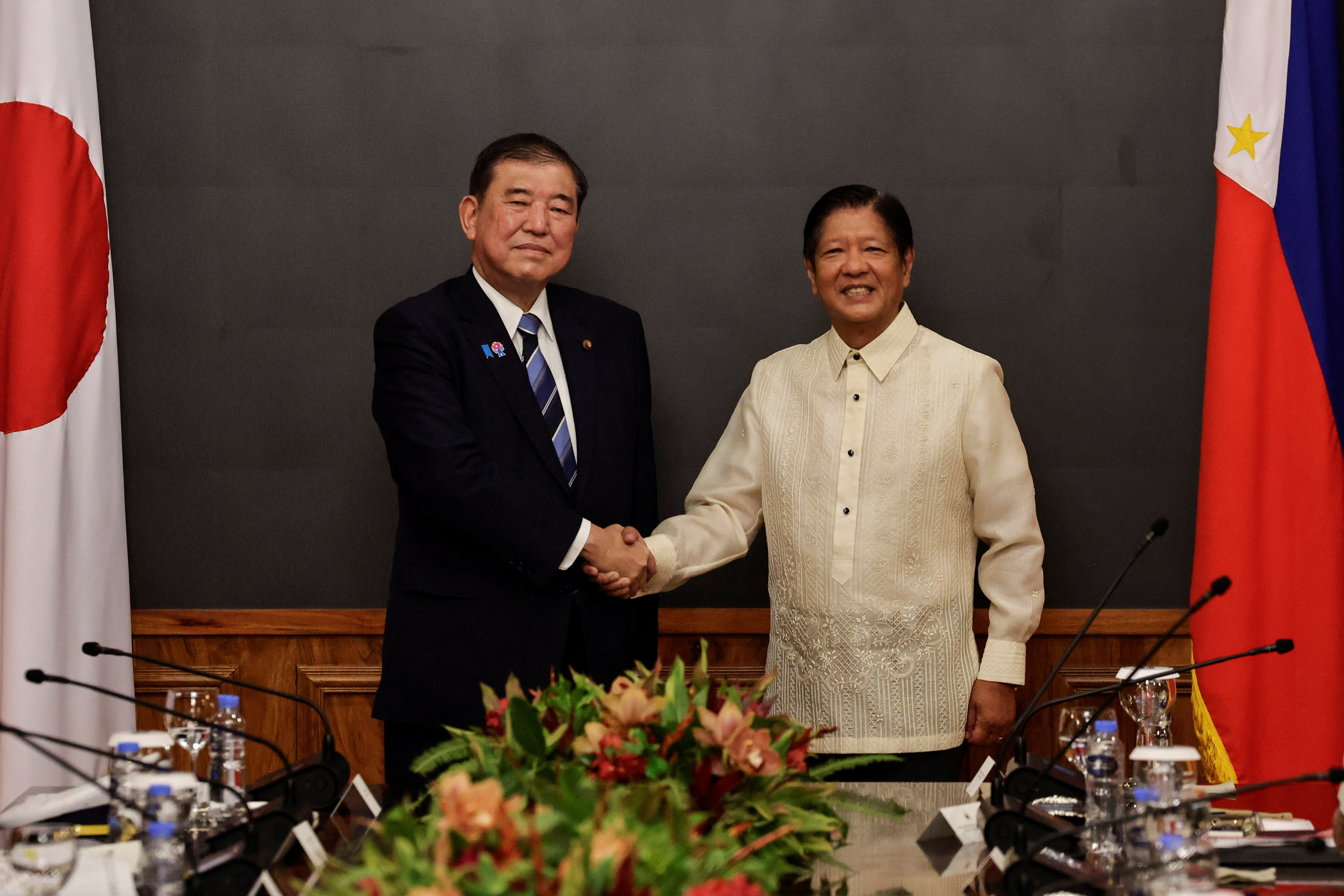 Japan's Prime Minister Shigeru Ishiba and Philippine President Ferdinand Marcos Jr. pose for press cameras ahead of a bilateral meeting at the Malacanang palace in Manila